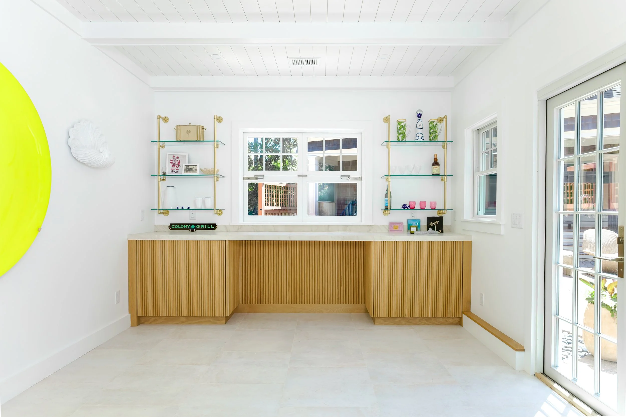 Luxury Osterville pool house with custom bar, natural wood cabinetry, coastal interior design, large windows, and premium entertaining space in a Cape Cod custom home.