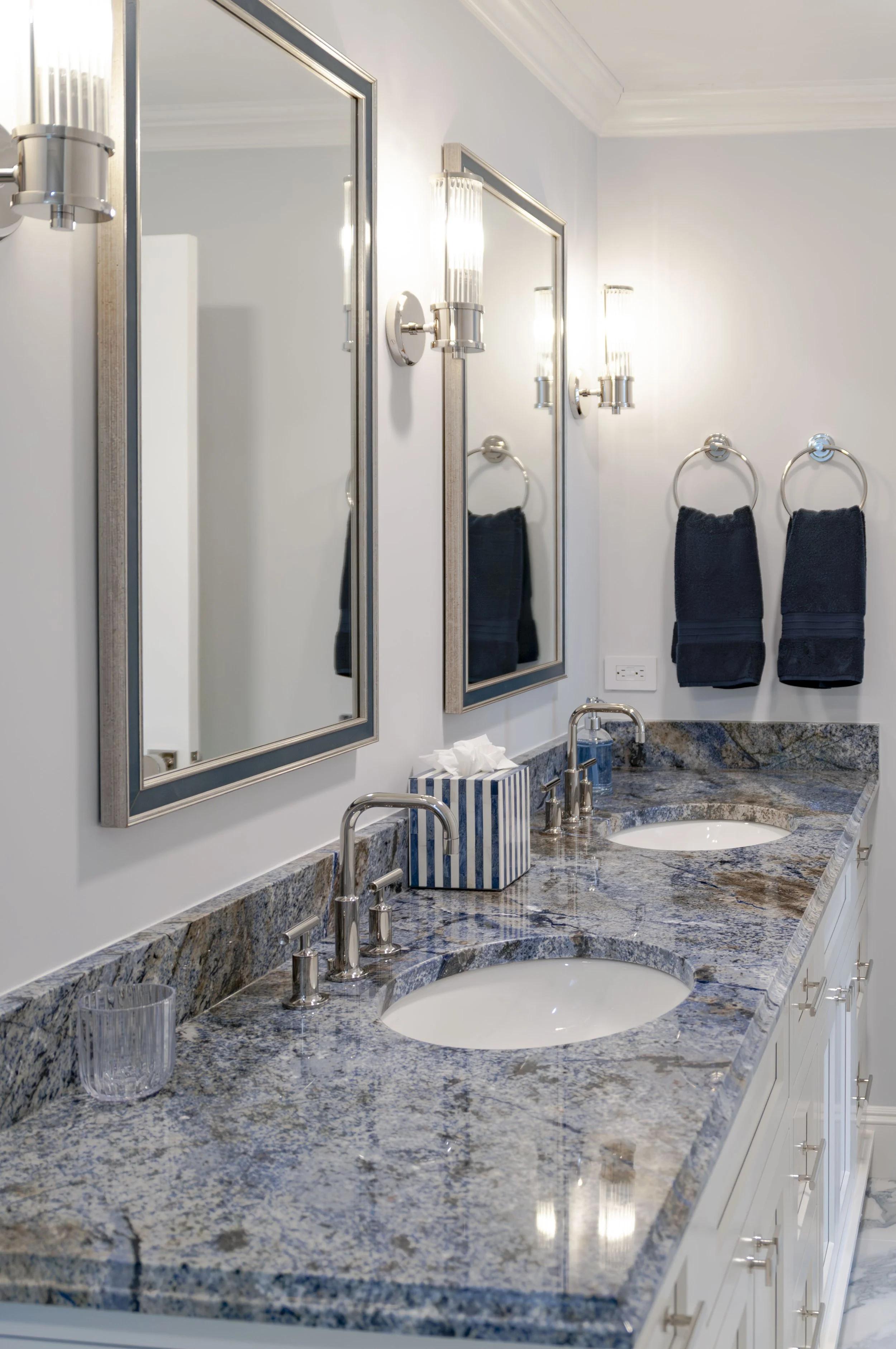 Double vanity in a Cape Cod custom home with blue stone counter, framed mirrors, and polished sconces.