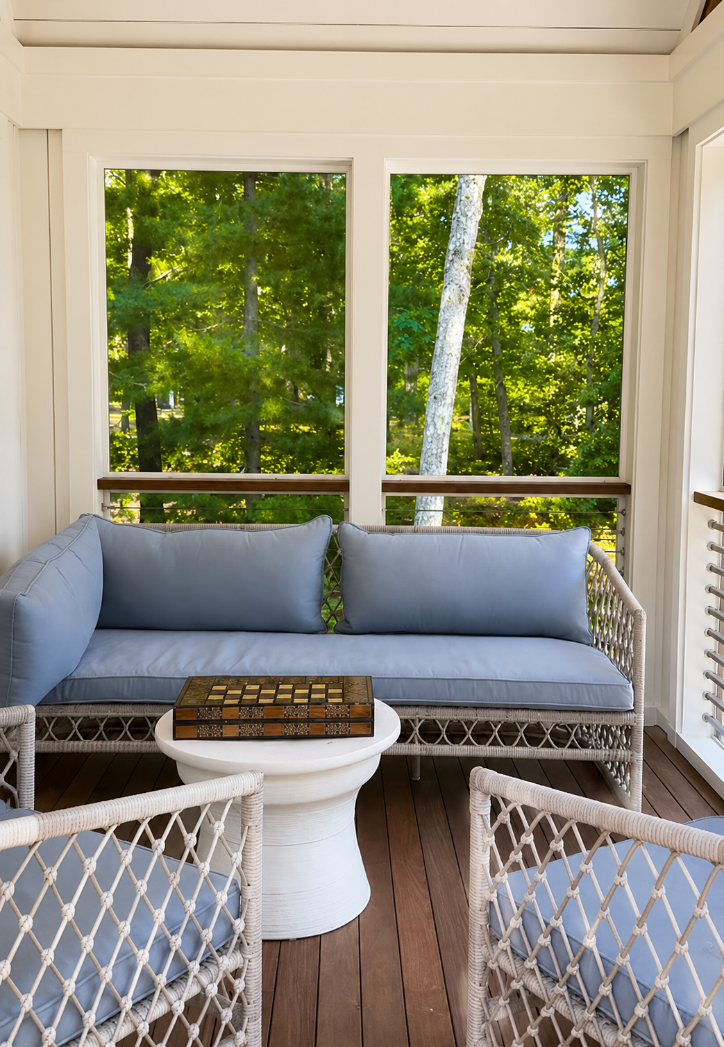 Sea View Builders designed this screened porch with custom trim, cable railings, woven furniture, and peaceful Cape Cod outdoor living.