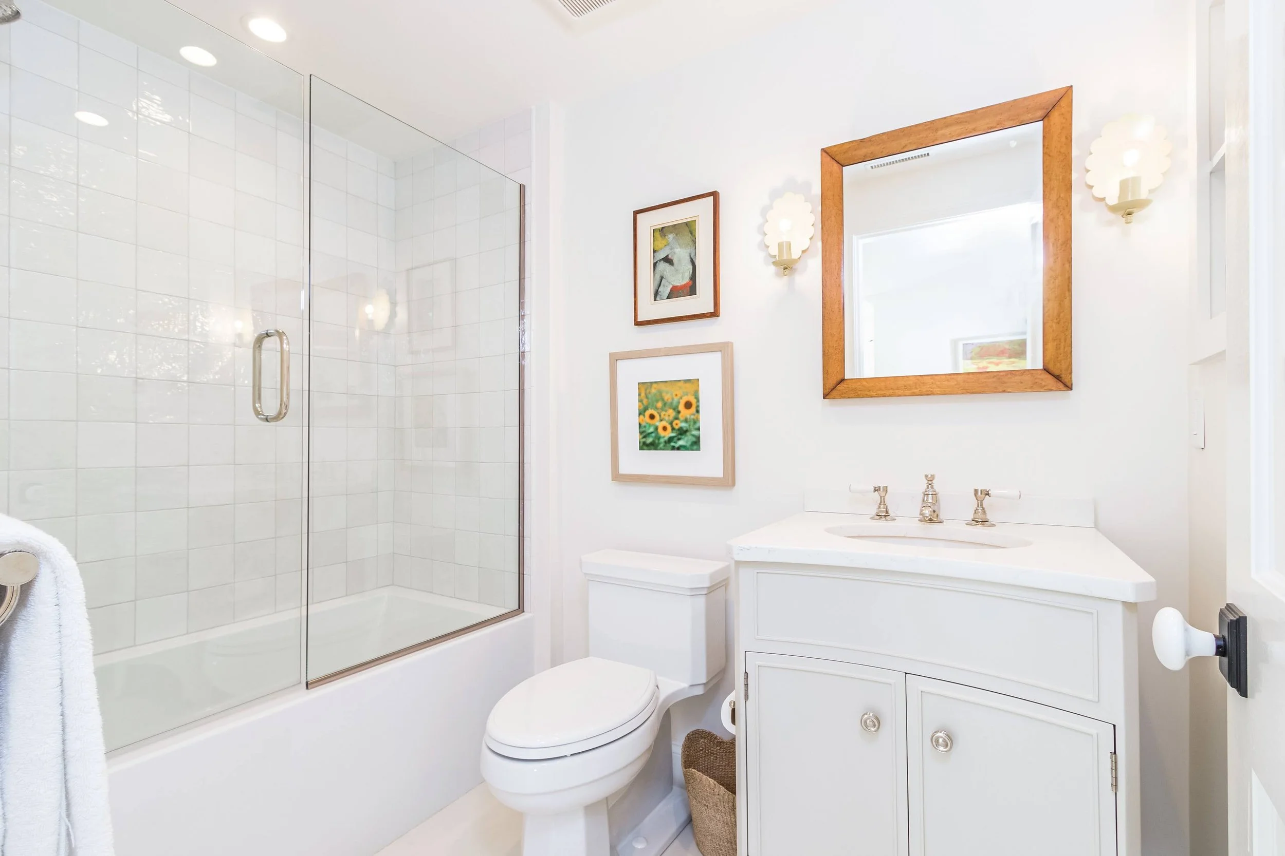 Polished marble finishes and a glass shower reflect custom home builder on Cape Cod craftsmanship in this bathroom.