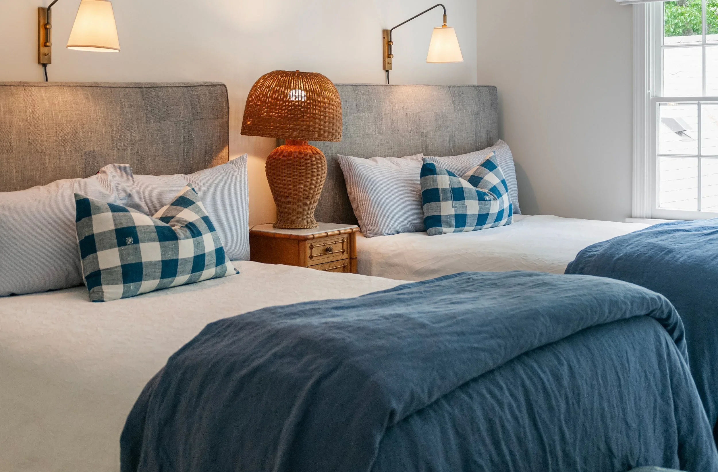 Sea View Builders designed this custom guest bedroom with twin beds, woven accents, designer lighting, and timeless Cape Cod coastal style.