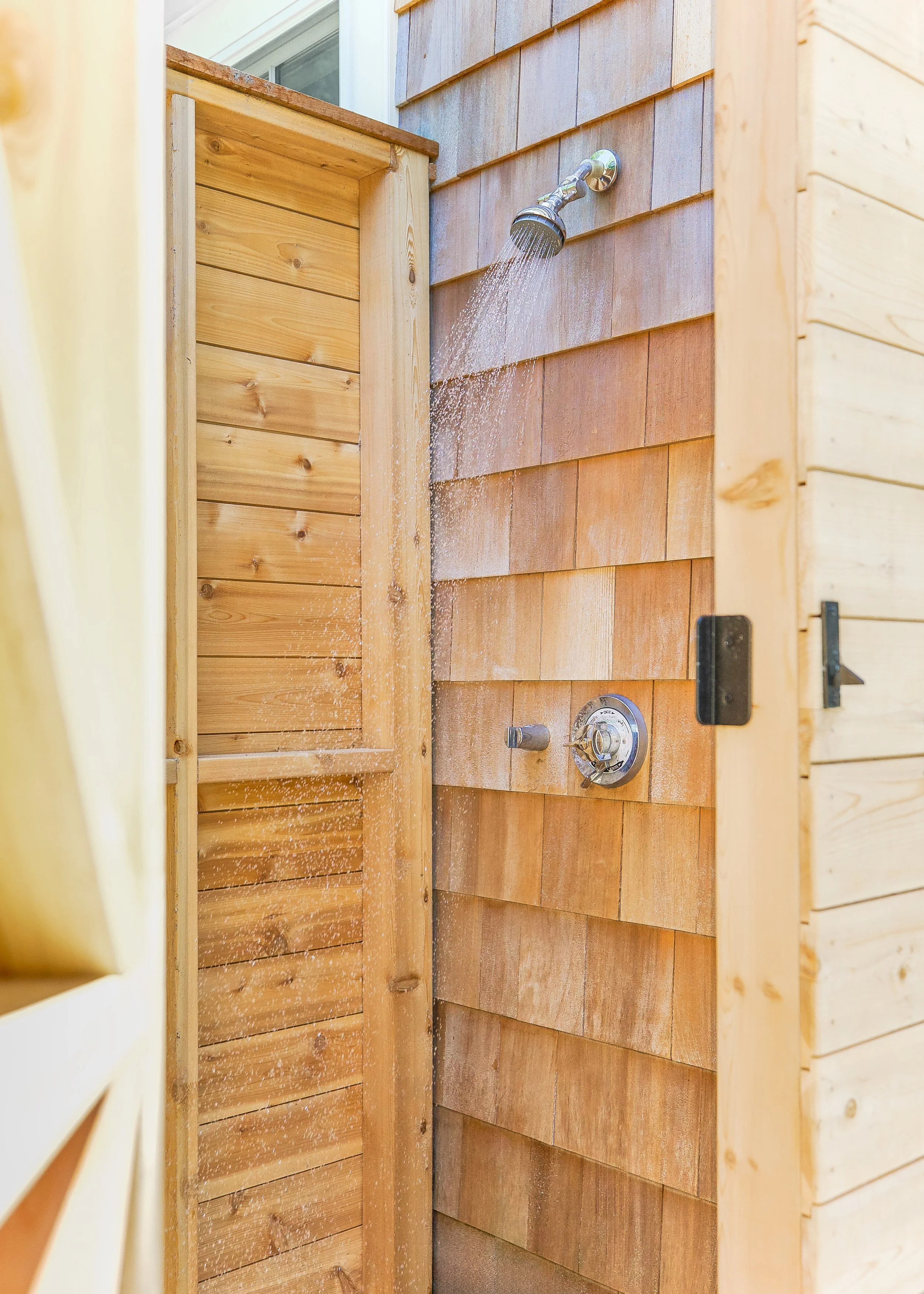 Cedar outdoor shower with shingled siding, running water, and Cape Cod poolside living detail.