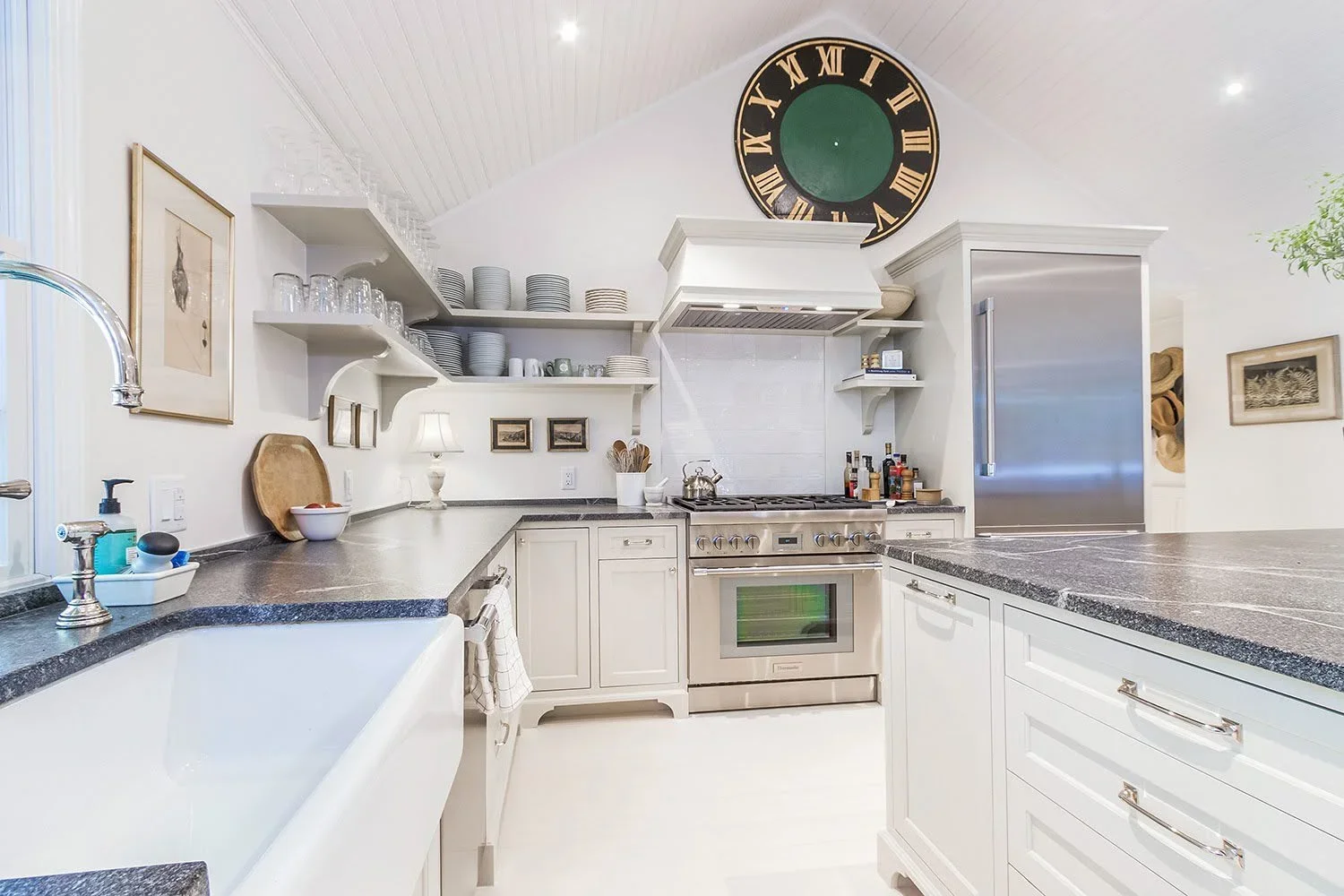 Sea View Builders designed this Cape Cod kitchen with custom cabinetry, a large center island, open shelving, and a chef-inspired cooking space.