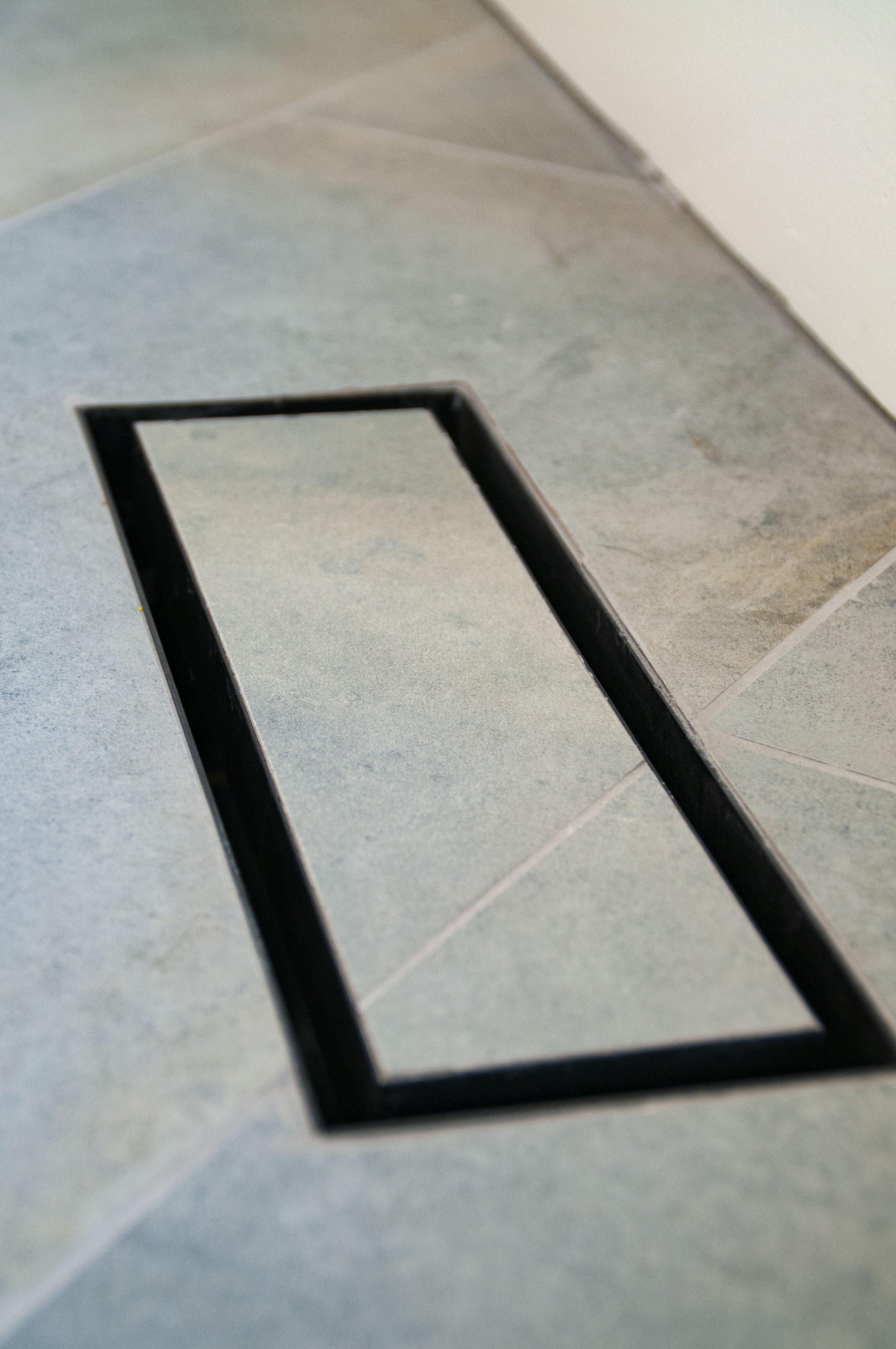 Cape Cod custom home flooring detail with gray tile and recessed linear floor vent.