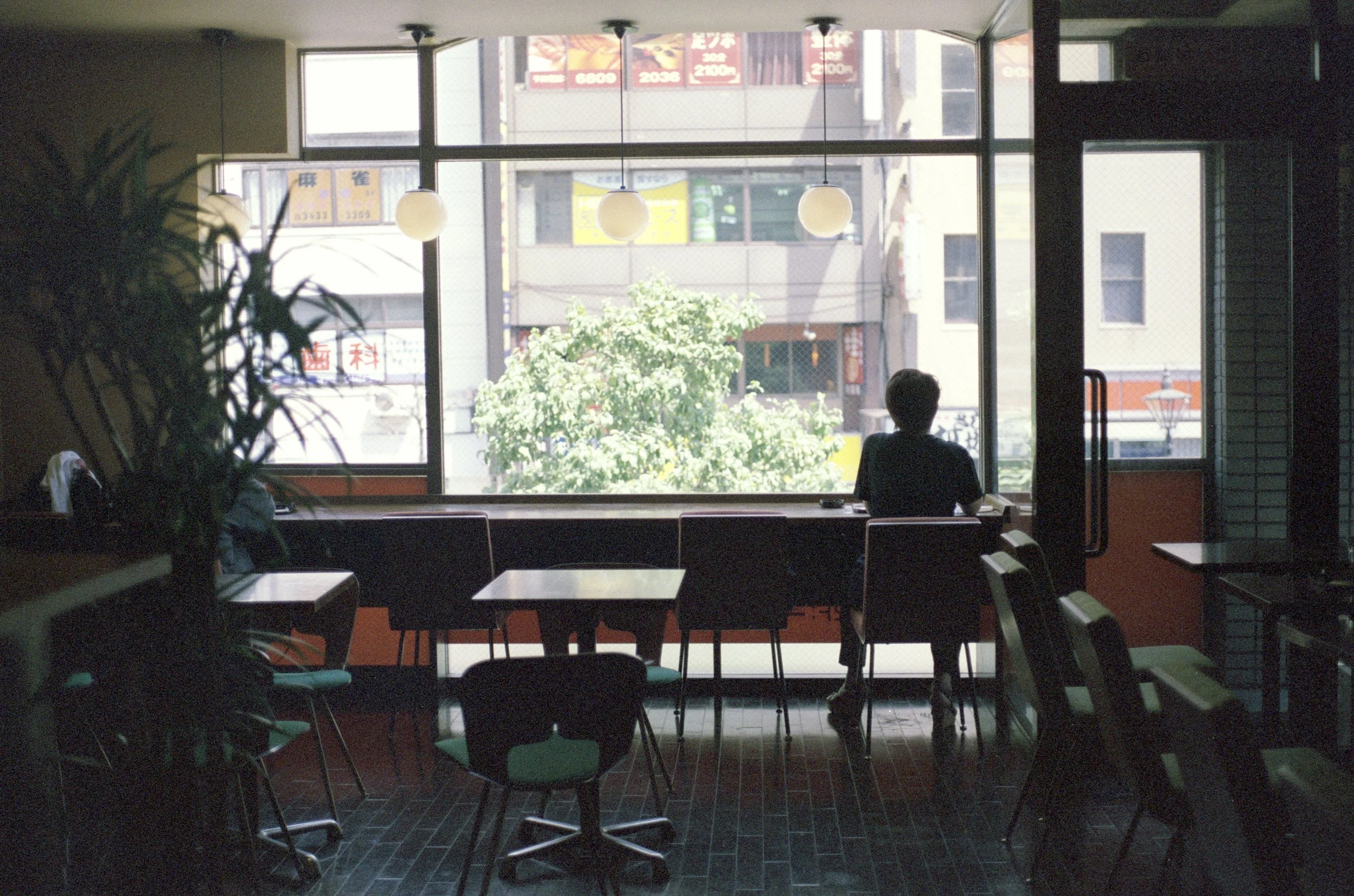 man sitting alone looking out window * ennis 35mm film photography japan street 2012