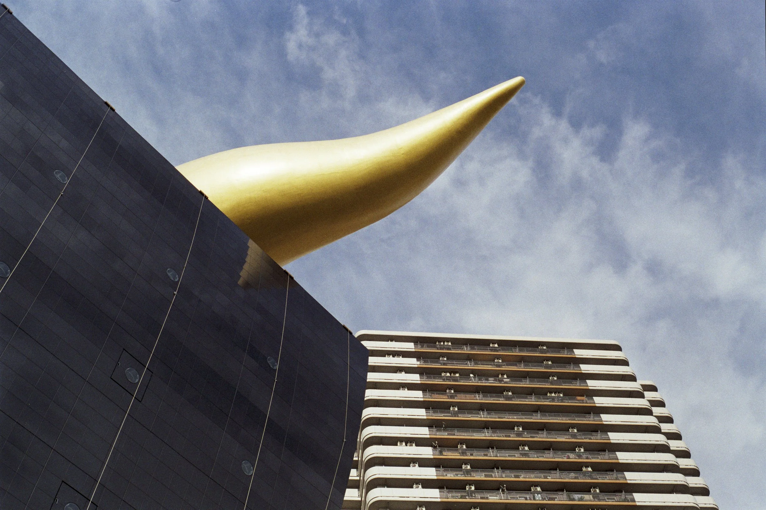 obscure gold giant sperm looking statue on building * blue sky * ennis 35mm film photography japan street 2012