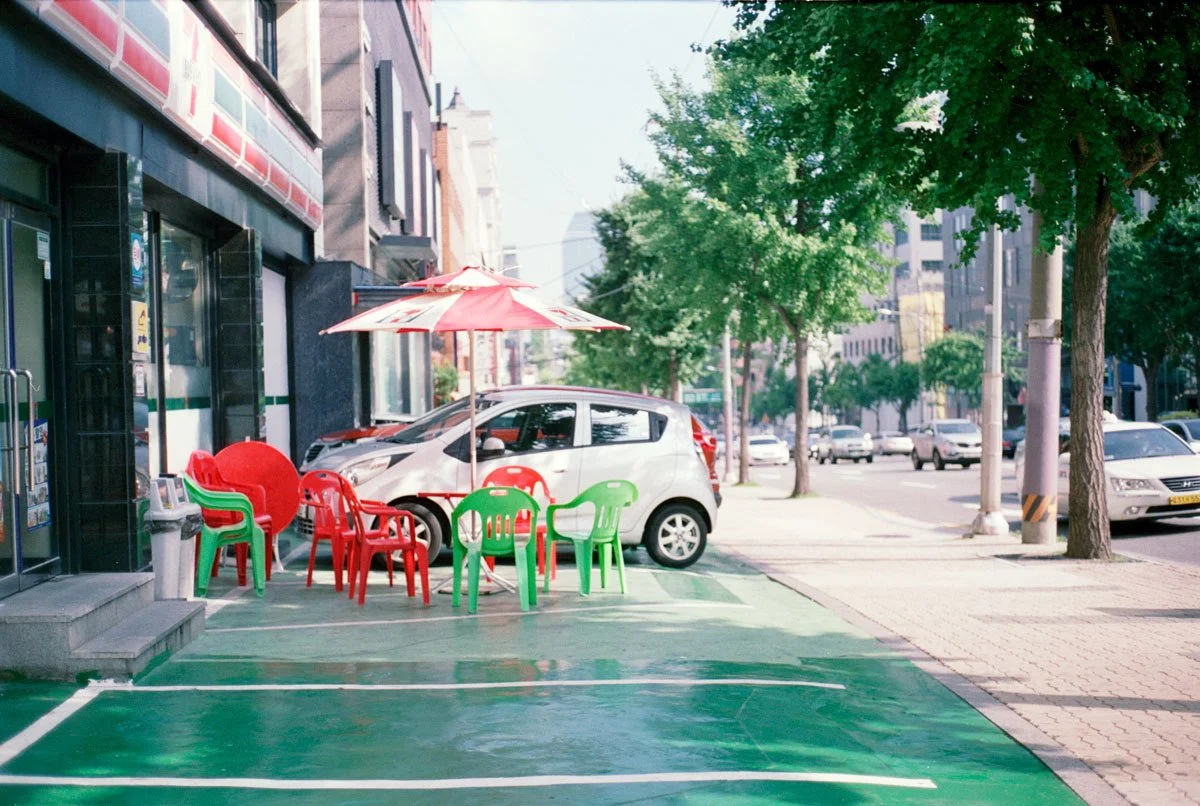 red and green plastic chairs outside convenience store summer daytime * ennis 35mm film street photography south korea seoul * 2012