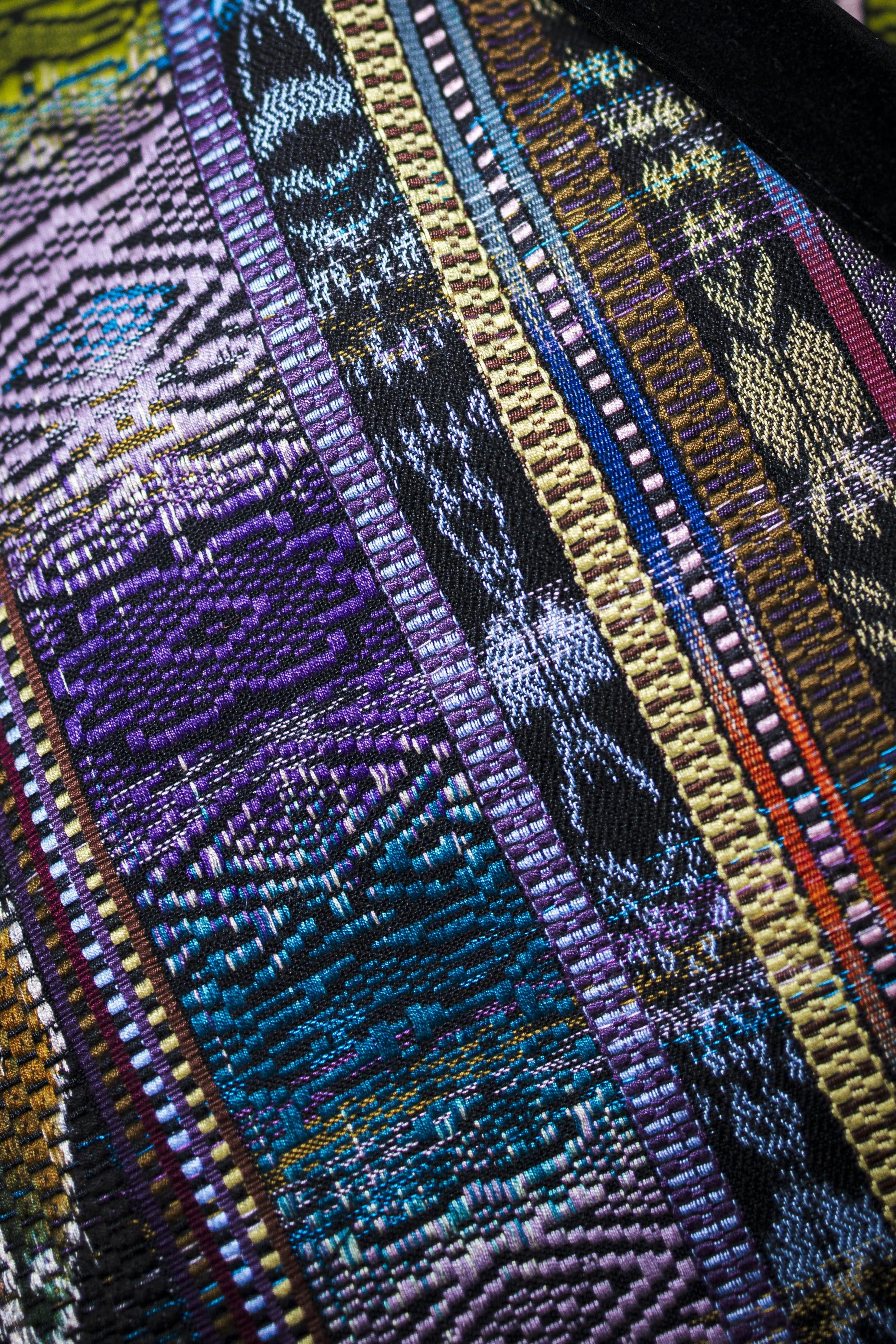 Close-up of colorful woven textile with intricate patterns and vibrant threads.