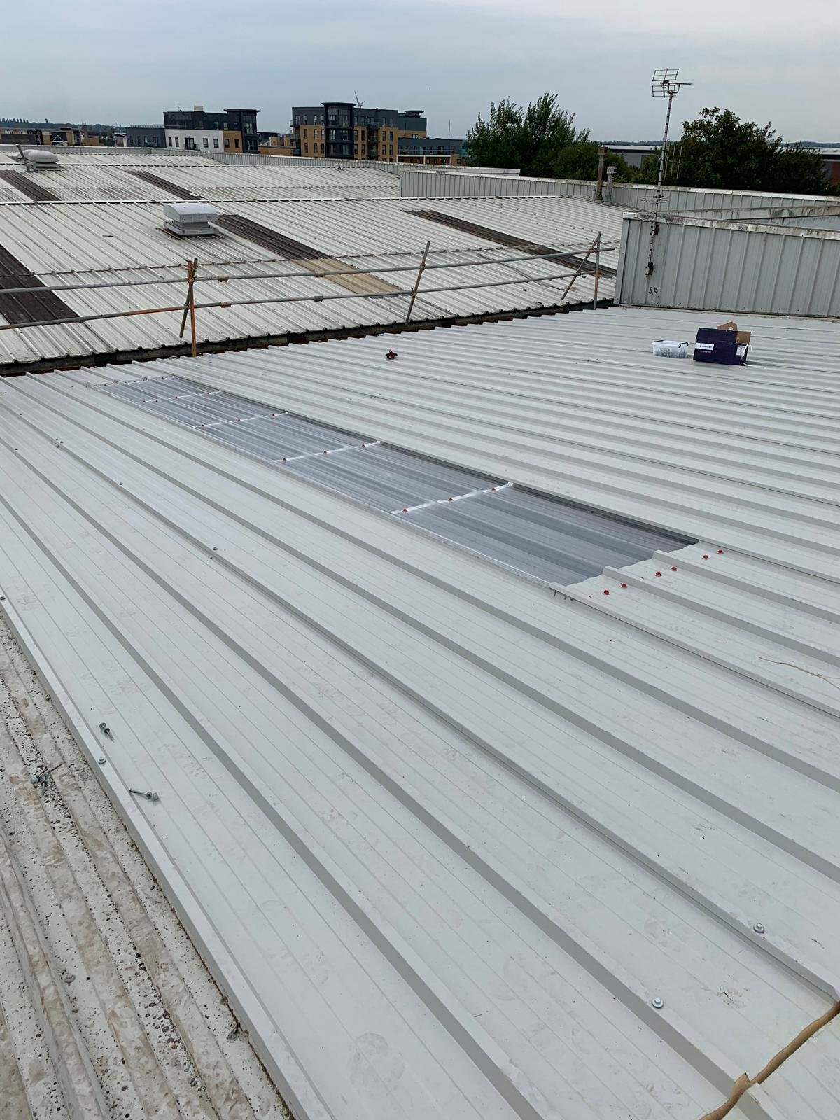 Industrial building roof with metal panels and skylight installation