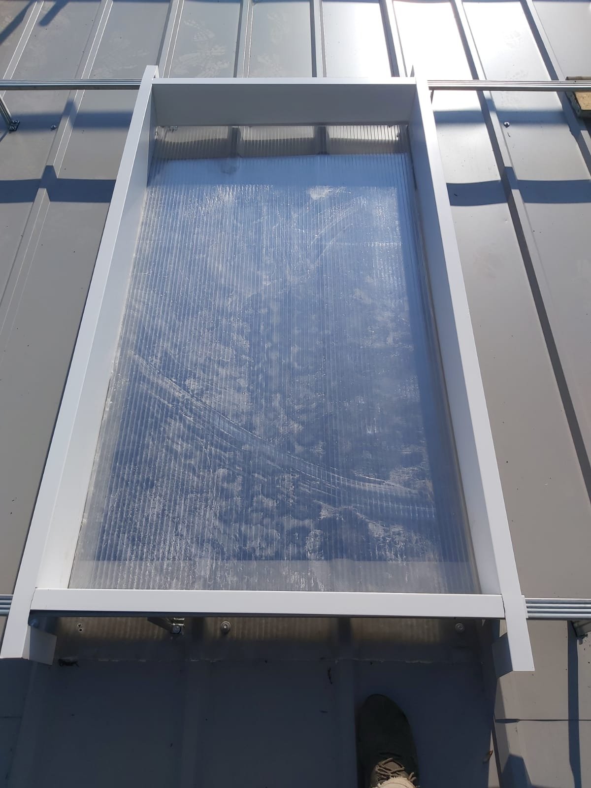 Rectangular glass or plastic panel on a flat metal roof, likely a skylight or solar panel.