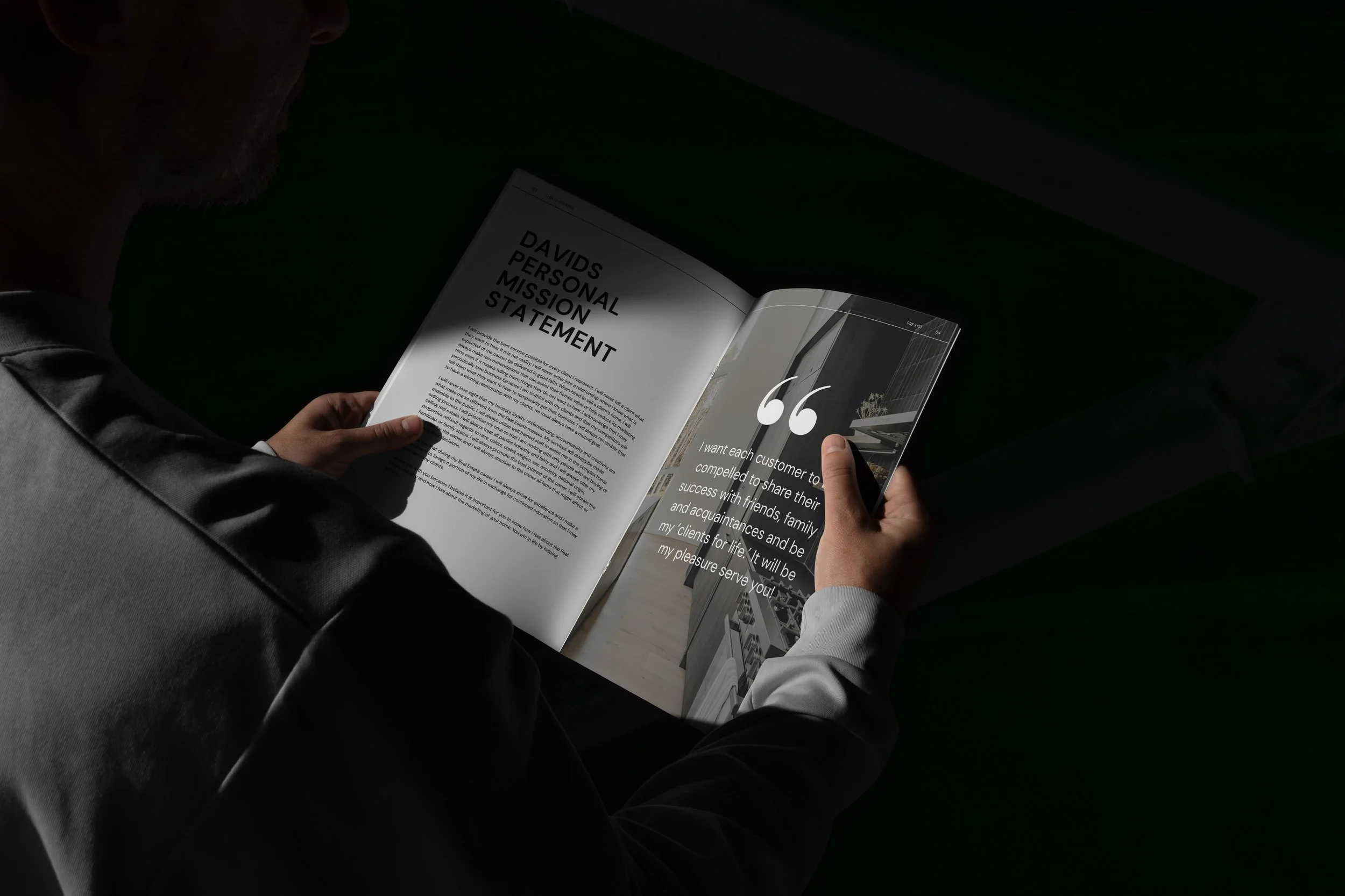 Person reading a magazine with text about personal mission statement and a quote about customer service, in a dimly lit environment.