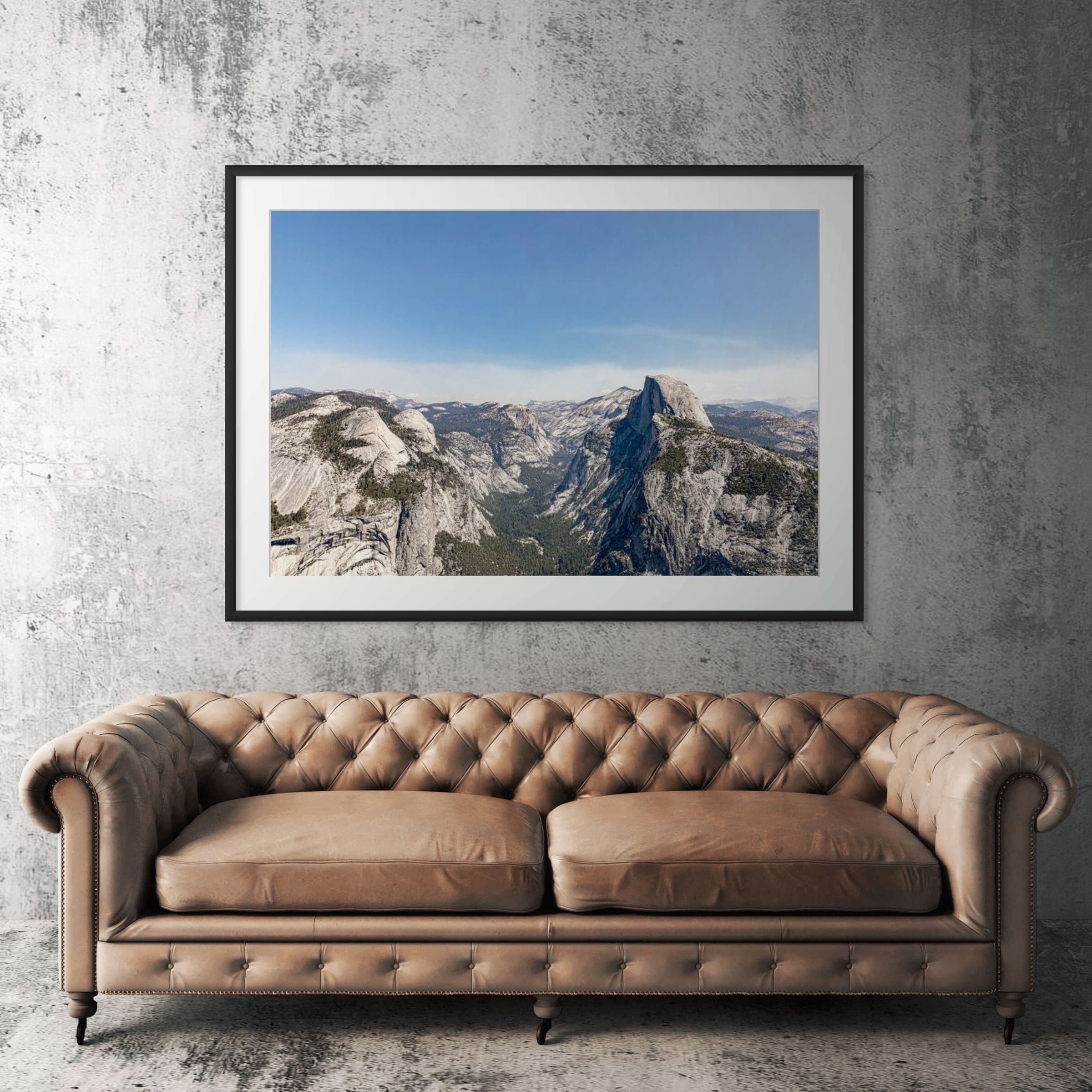 Yosemite Glacier Point view framed print displayed above tan leather sofa in living room