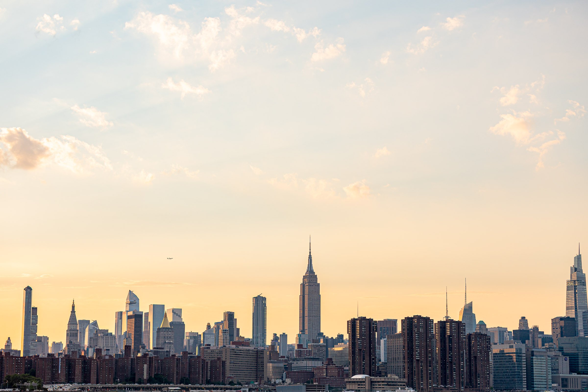 Manhattan skyline at dusk with skyscrapers reflecting light viewed from Brooklyn New York