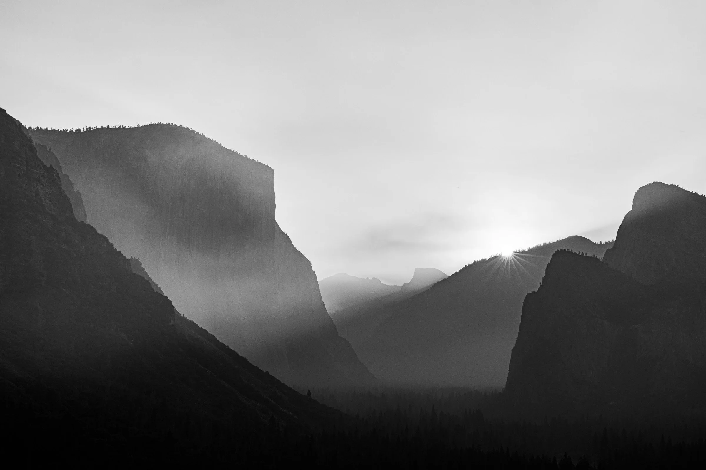 Black and white Yosemite Valley sunrise from Tunnel View with layered granite cliffs and mist California