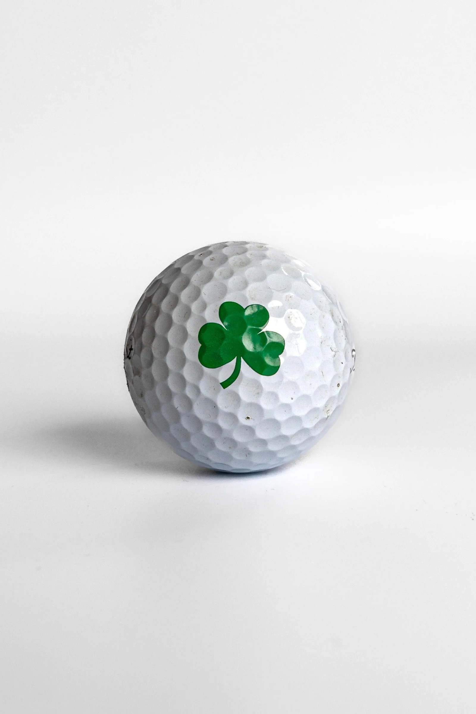 Titleist Pro V1 golf ball with green shamrock clover graphic white background