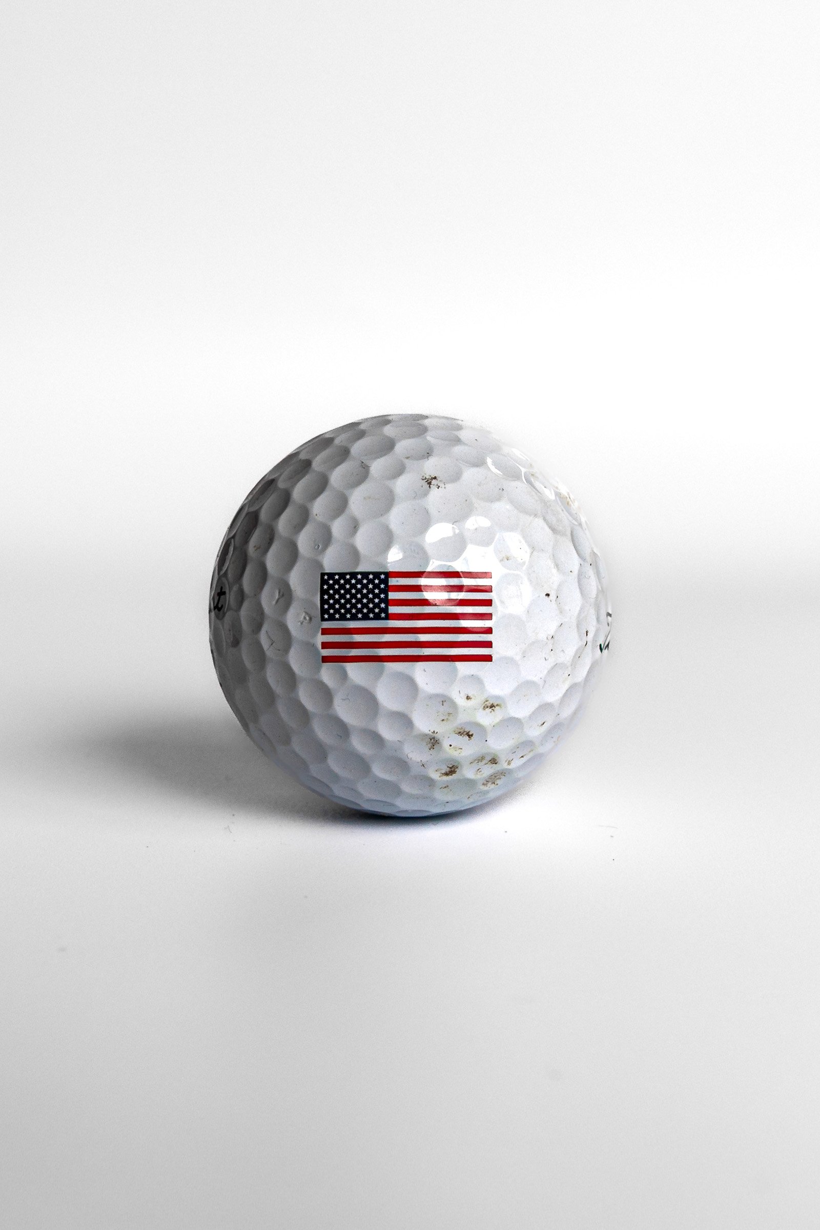 Titleist Pro V1 golf ball with American flag stars and stripes centered white background