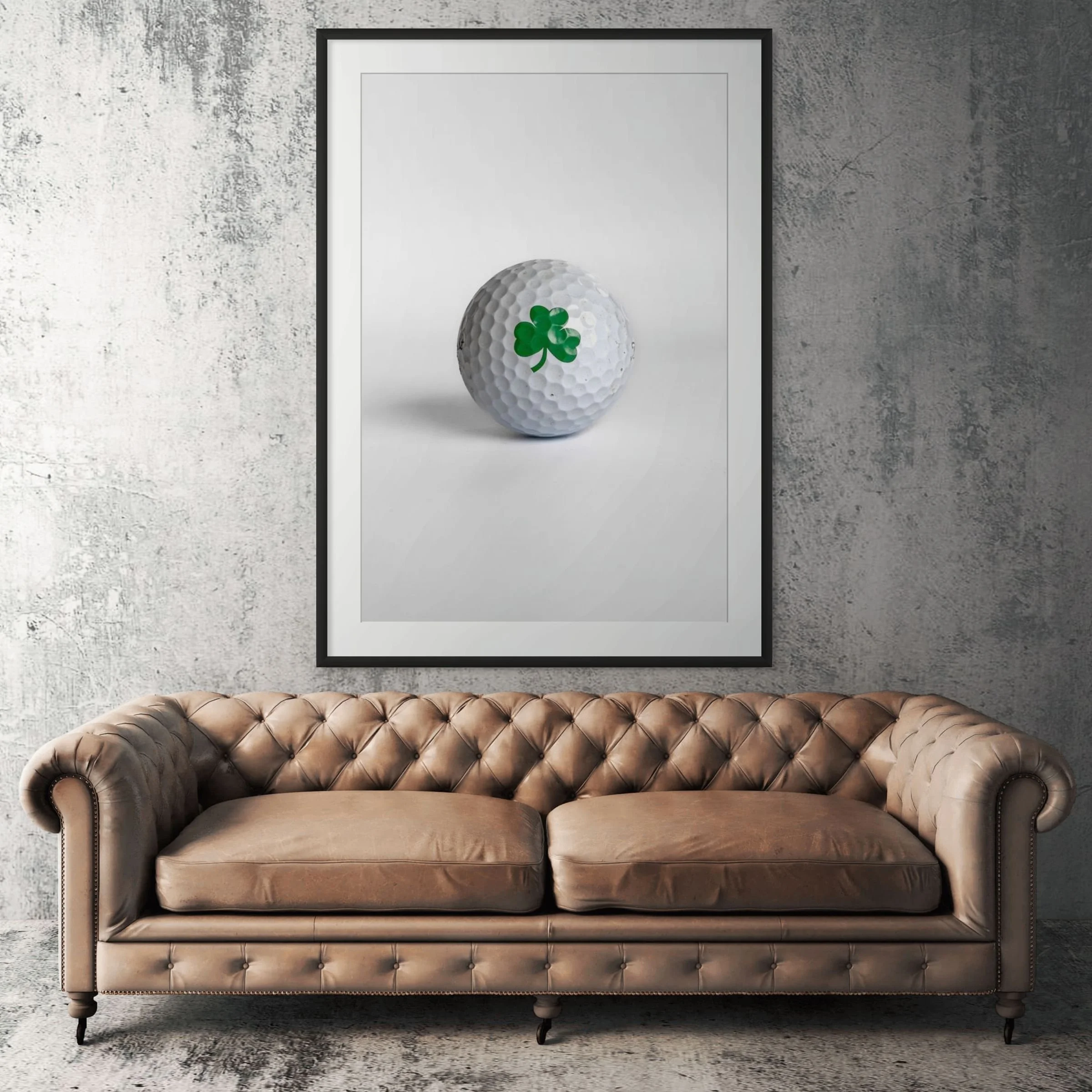 Titleist Pro V1 shamrock clover golf ball framed print displayed above tan leather sofa in living room