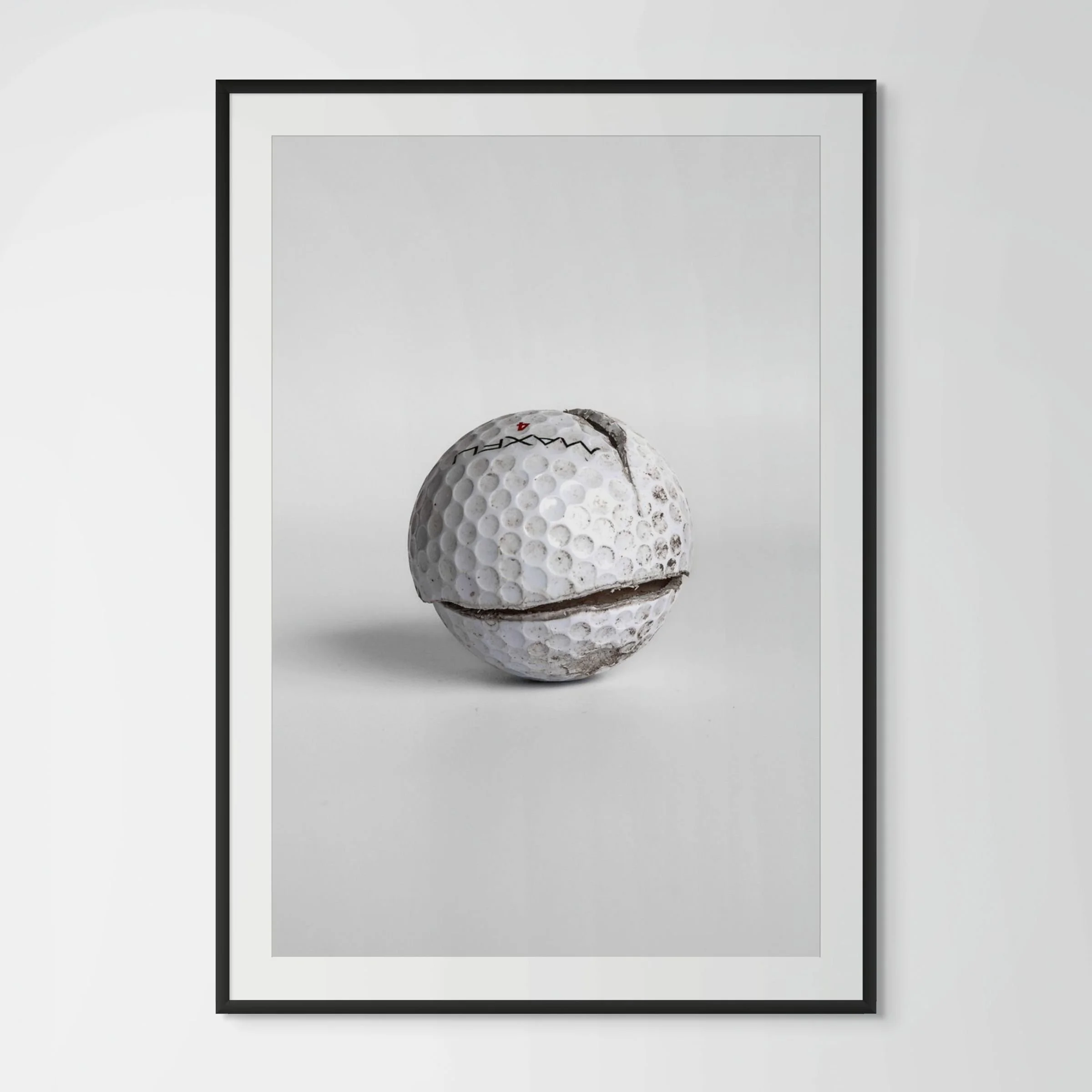 Maxfli Revolution cracked golf ball framed photography print in black wood frame