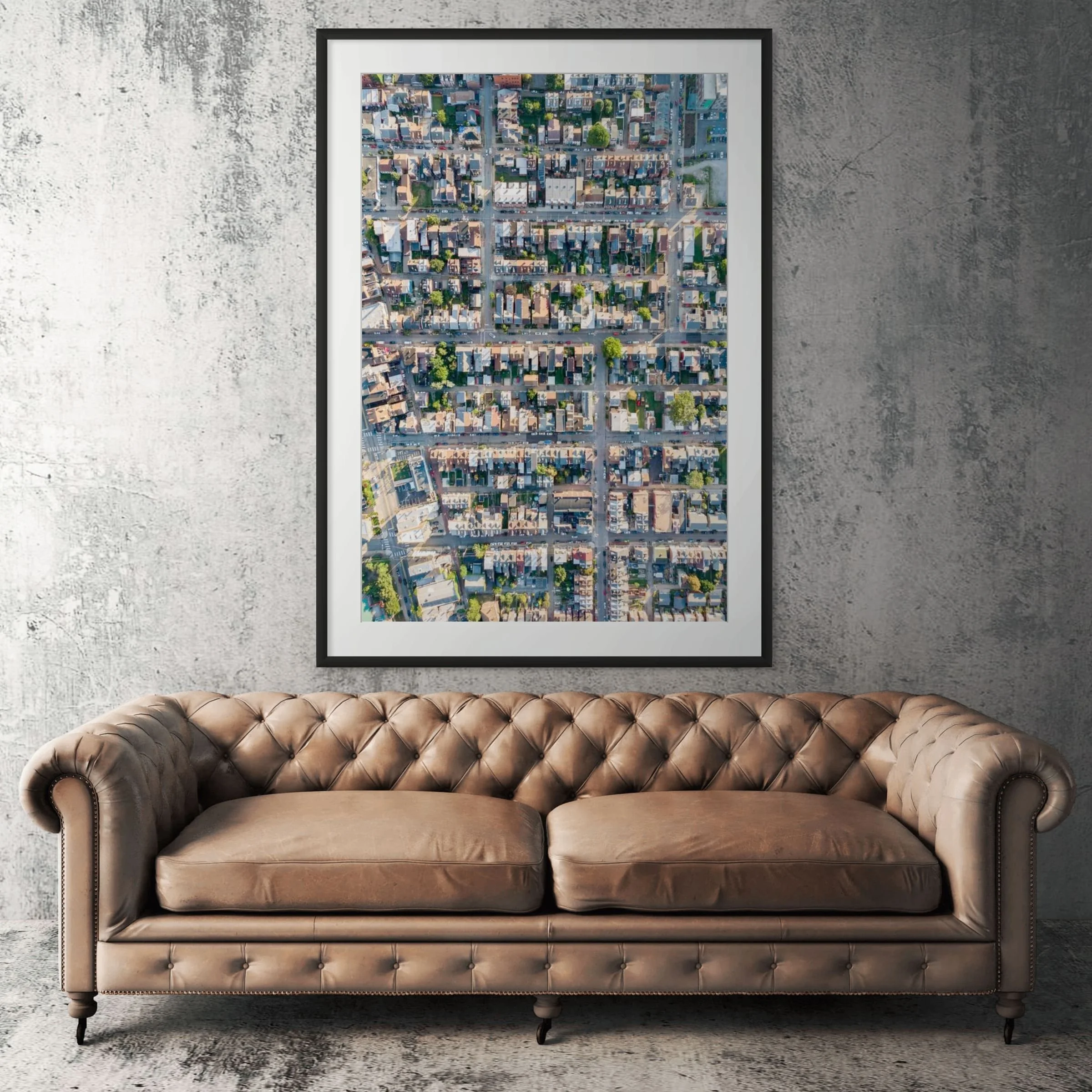 Lawrenceville streets aerial framed print displayed above tan leather sofa in living room