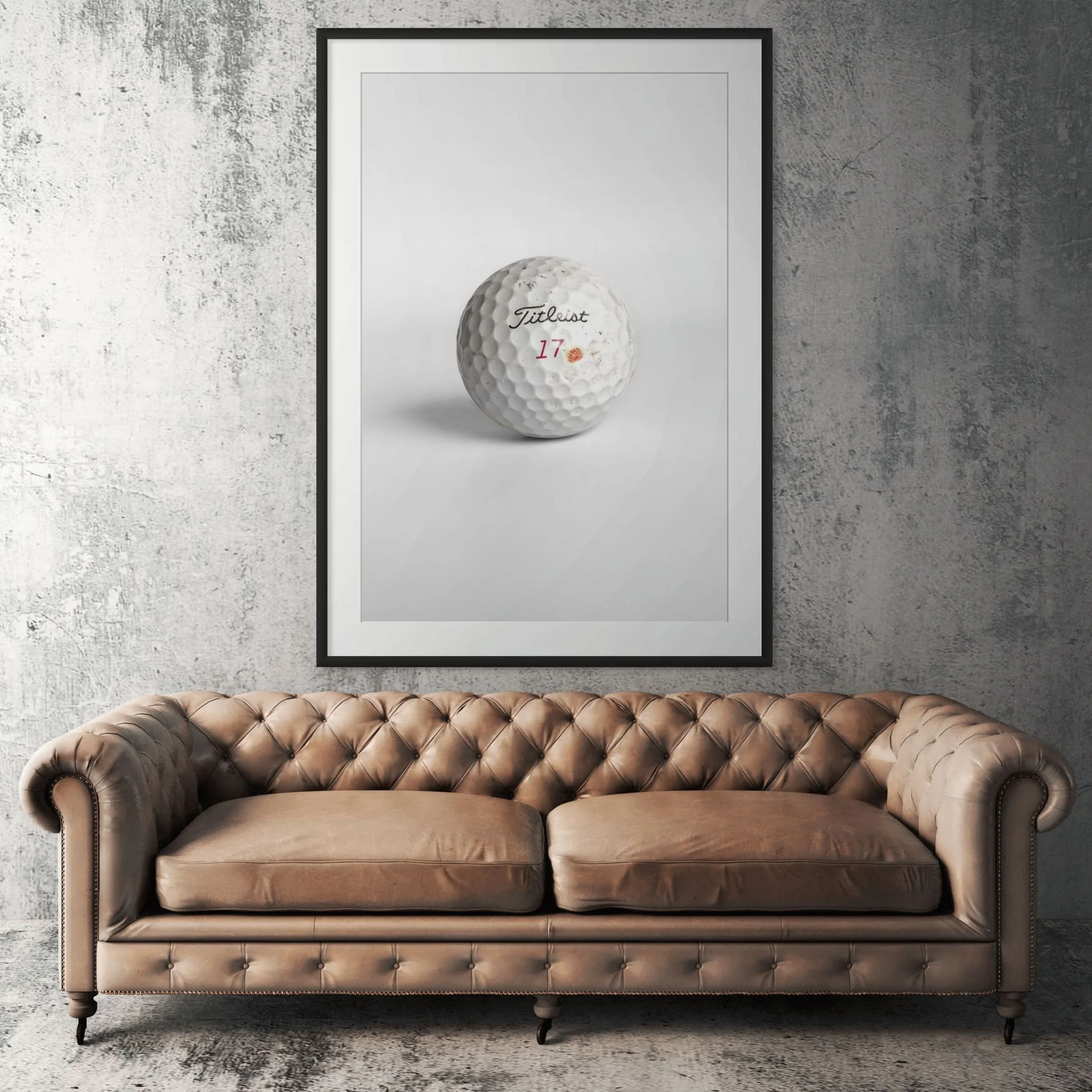 Titleist Pro V1x seventeen golf ball framed print displayed above tan leather sofa in living room