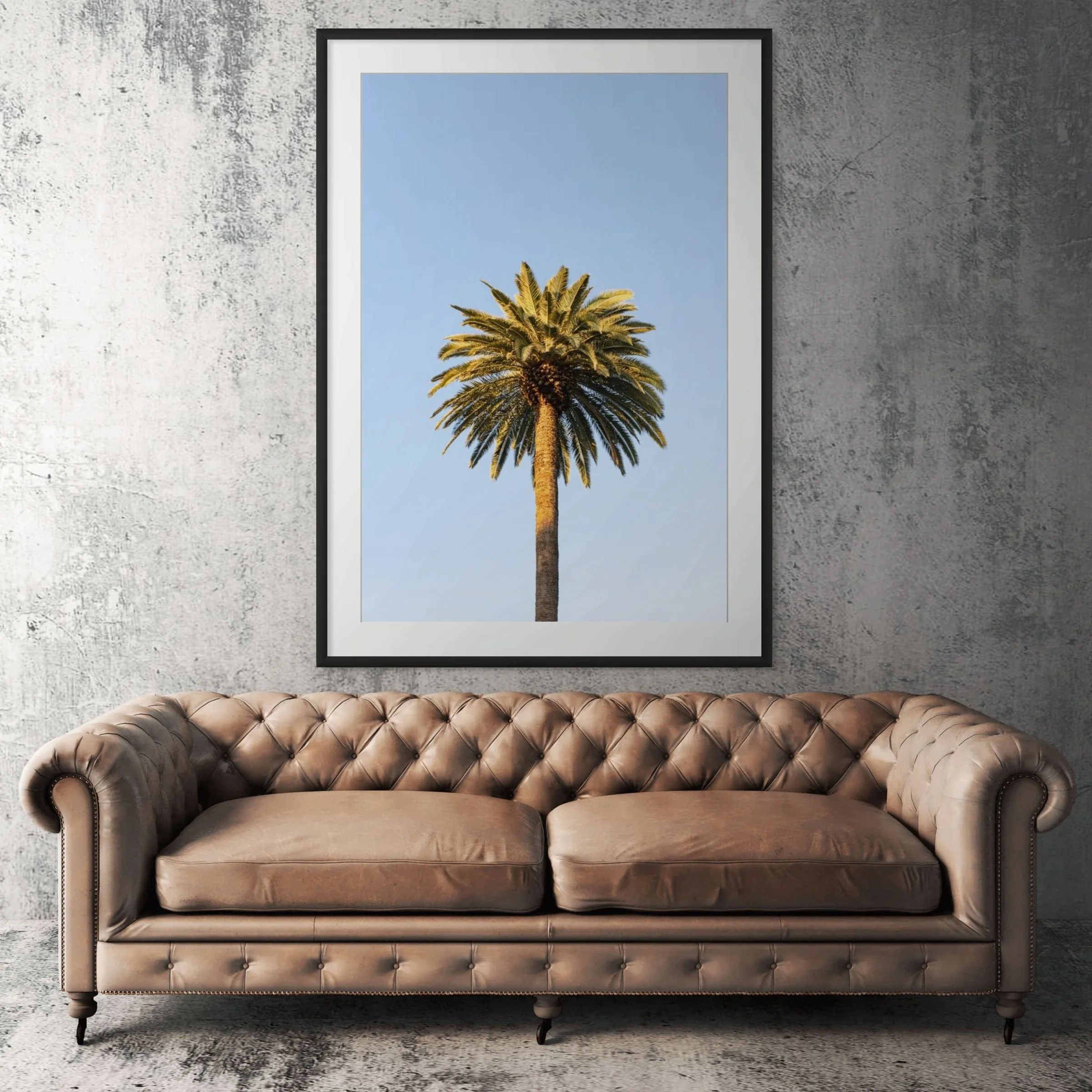 Santa Monica palm tree framed print displayed above tan leather sofa in living room