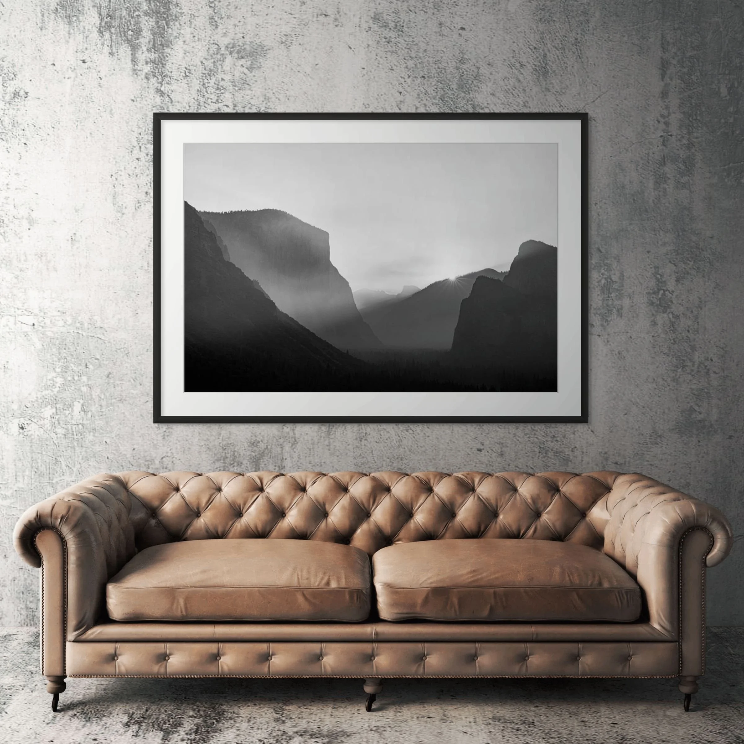 Yosemite Tunnel View black and white framed print displayed above tan leather sofa in living room