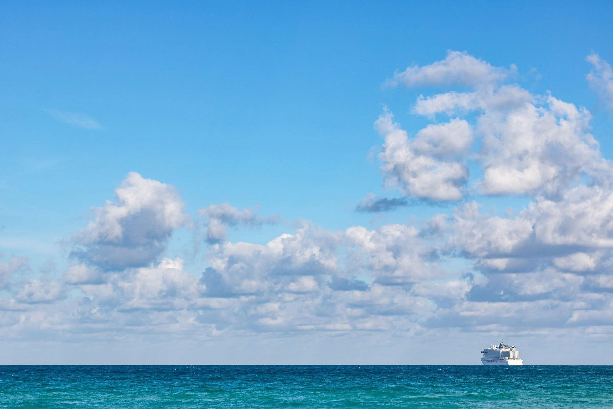 Miami Beach Atlantic Ocean view with cruise ship on horizon and dramatic clouds Florida