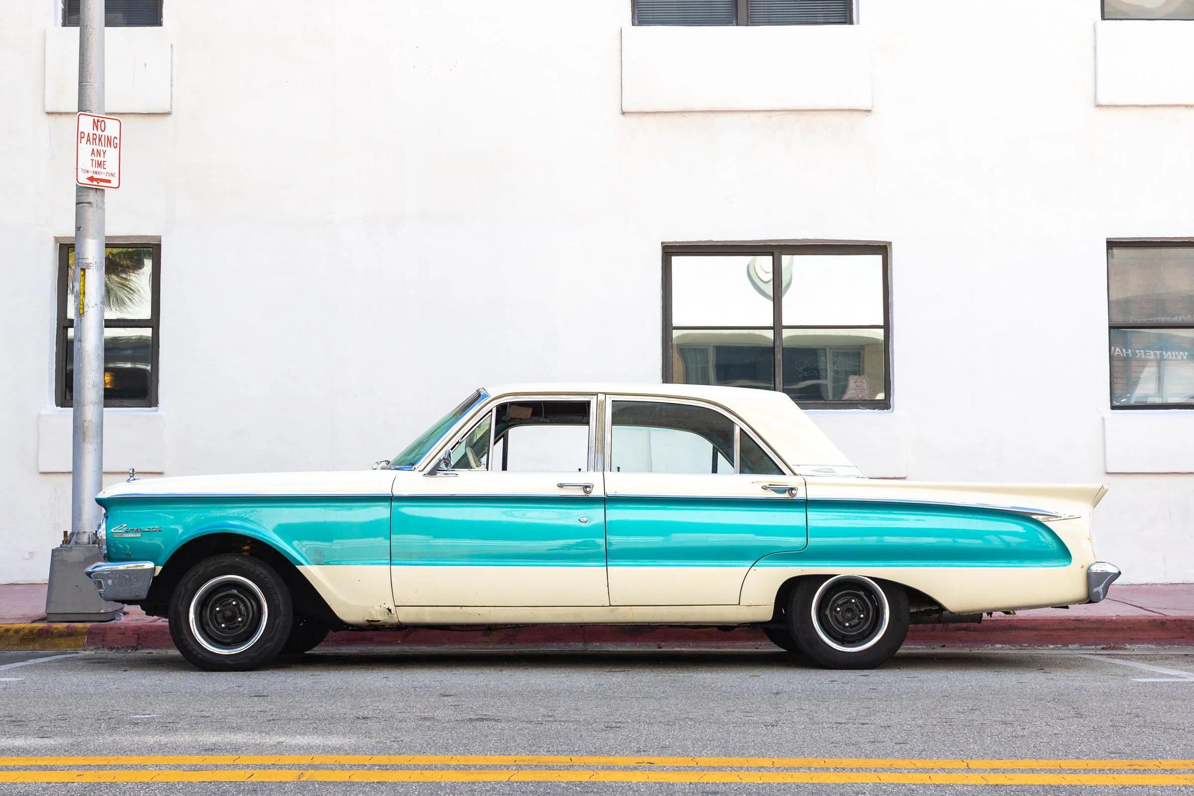Two-tone turquoise and cream classic car parked on Ocean Drive Miami Beach Florida street scene