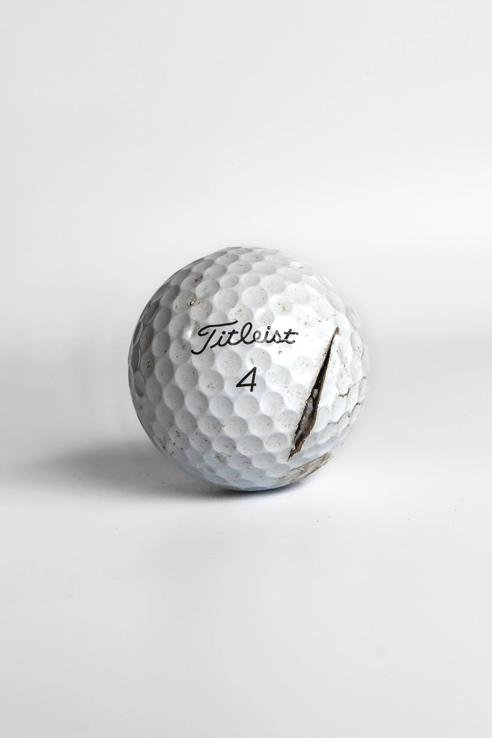 Titleist Pro V1 clean golf ball with single vertical crack white background