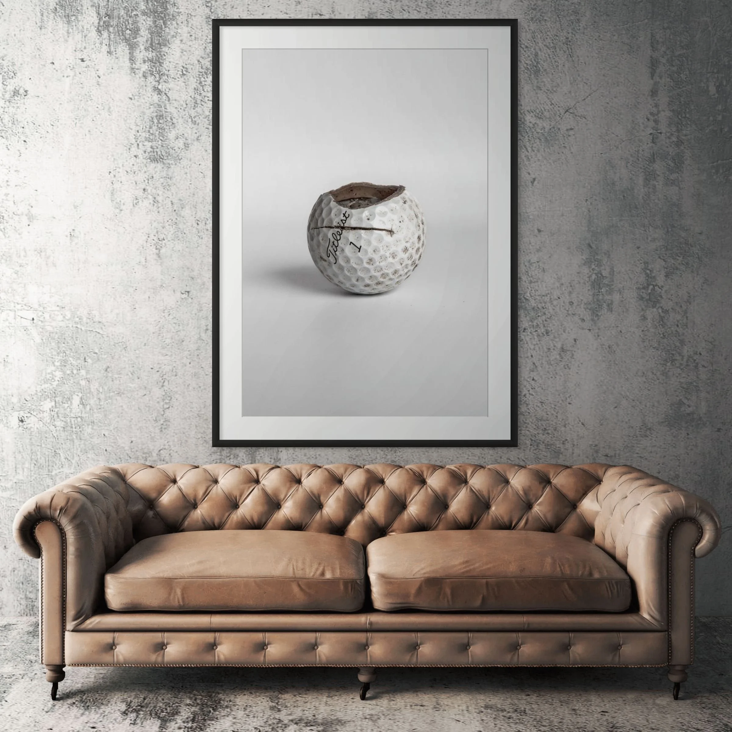 Titleist Pro V1 equator crack golf ball framed print displayed above tan leather sofa in living room