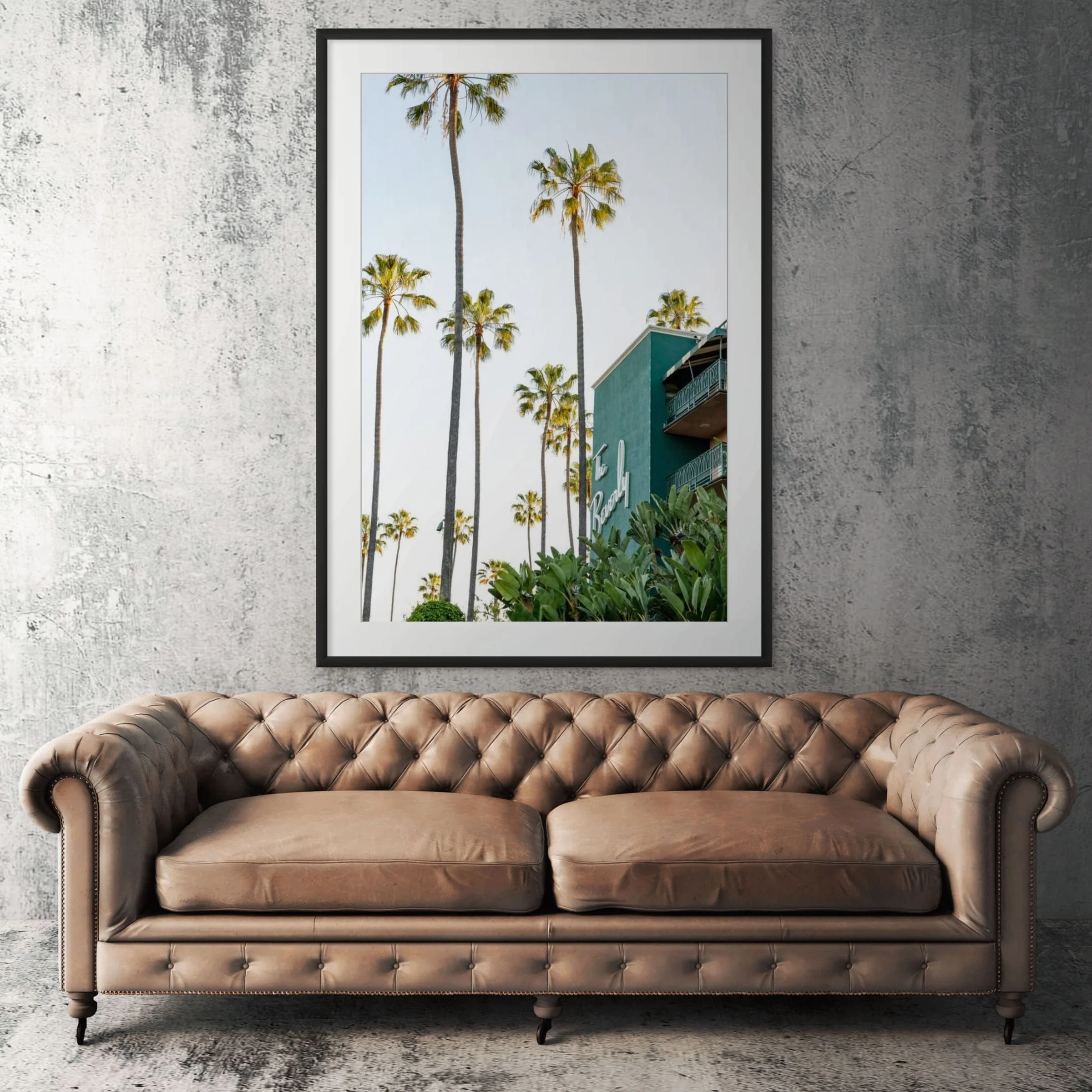 Beverly Hills Hotel framed print displayed above tan leather sofa in living room