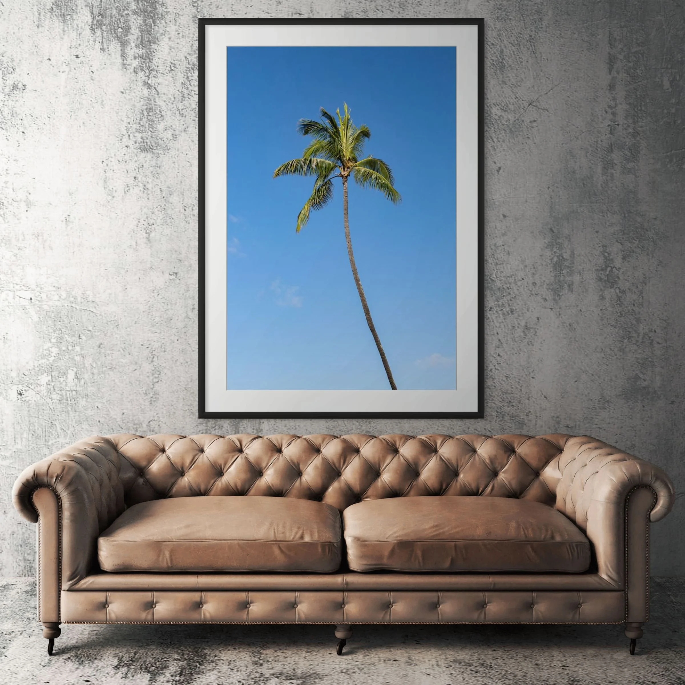 Hawaii palm tree beach framed print displayed above tan leather sofa in living room