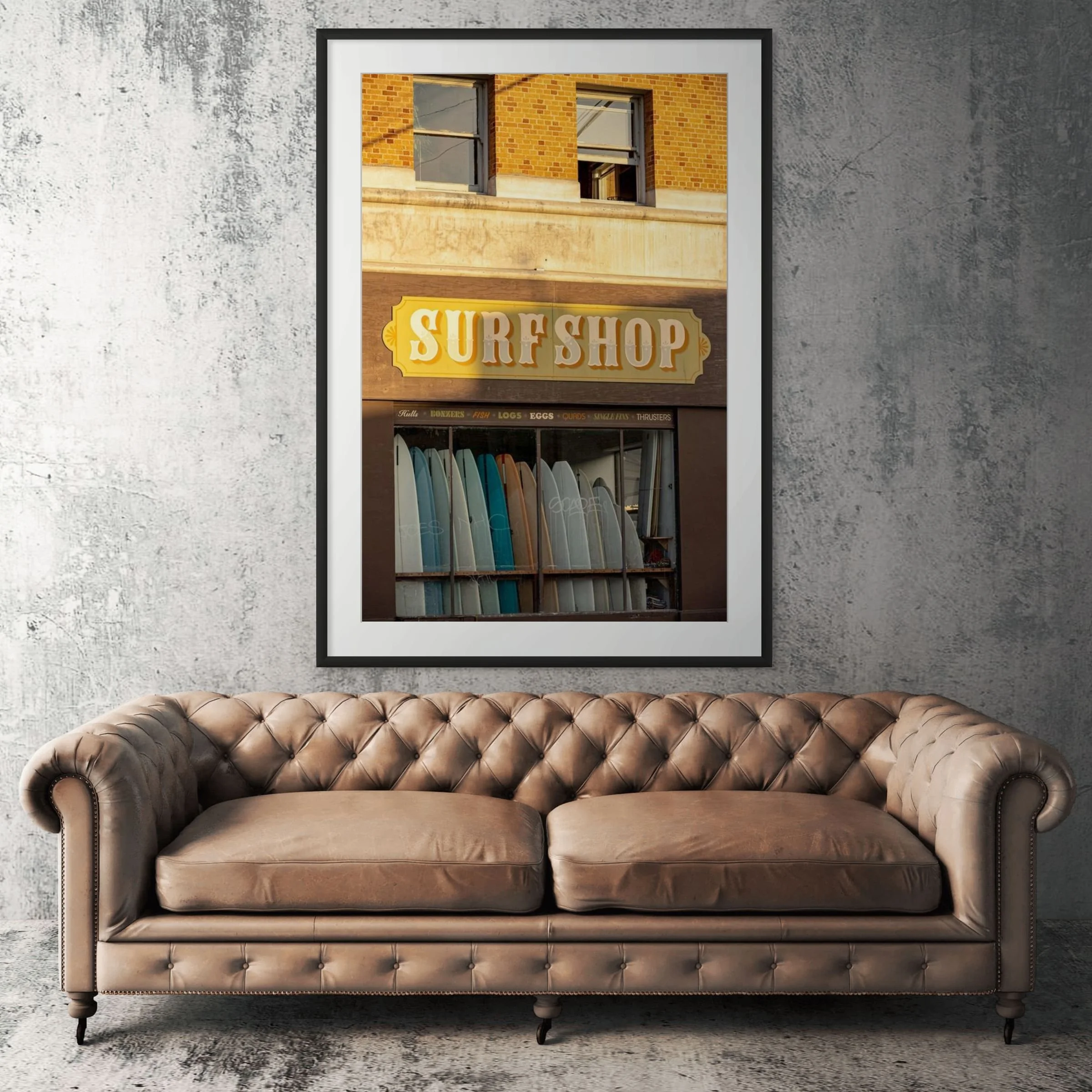 Venice Beach surf shop framed print displayed above tan leather sofa in living room