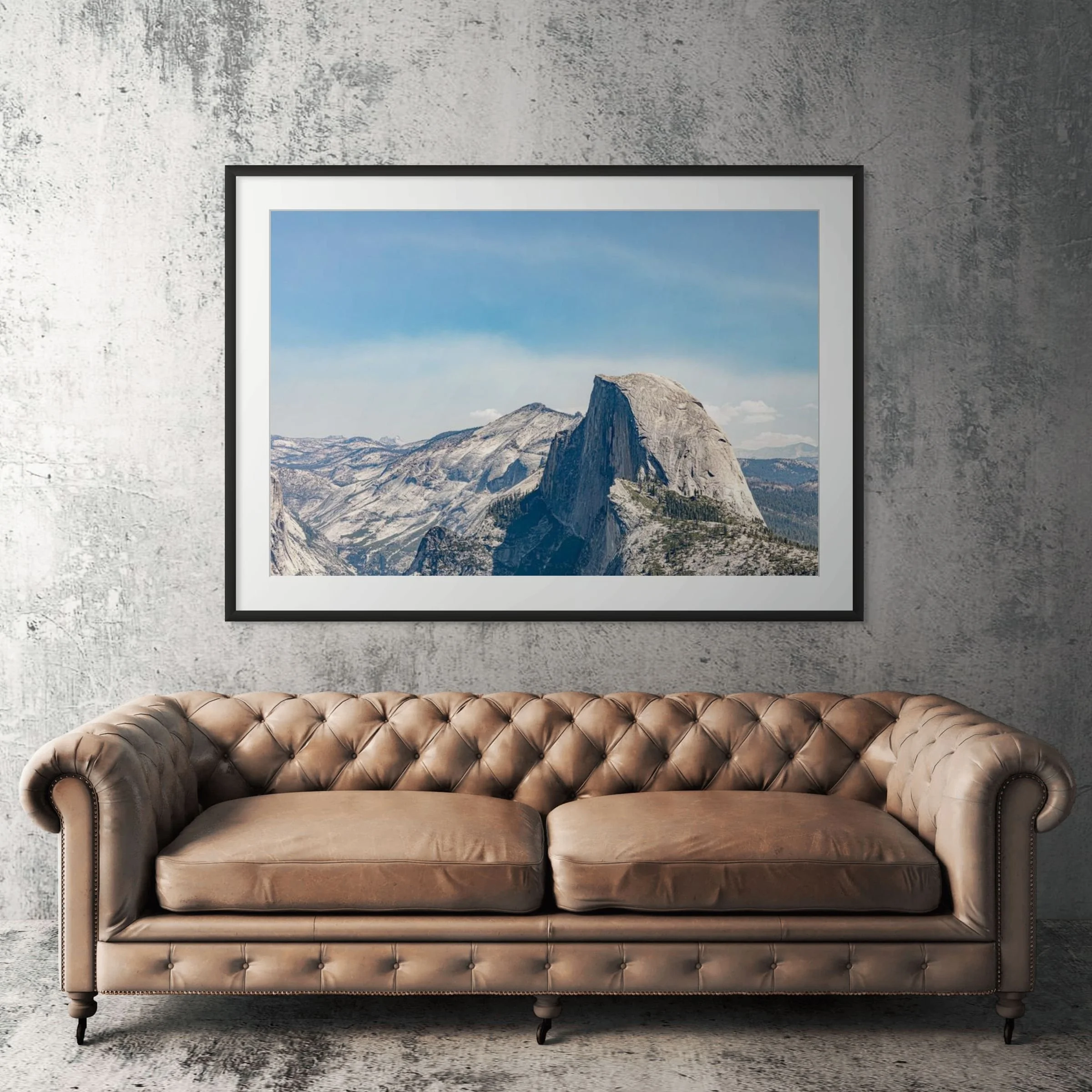 Yosemite Half Dome framed print displayed above tan leather sofa in living room