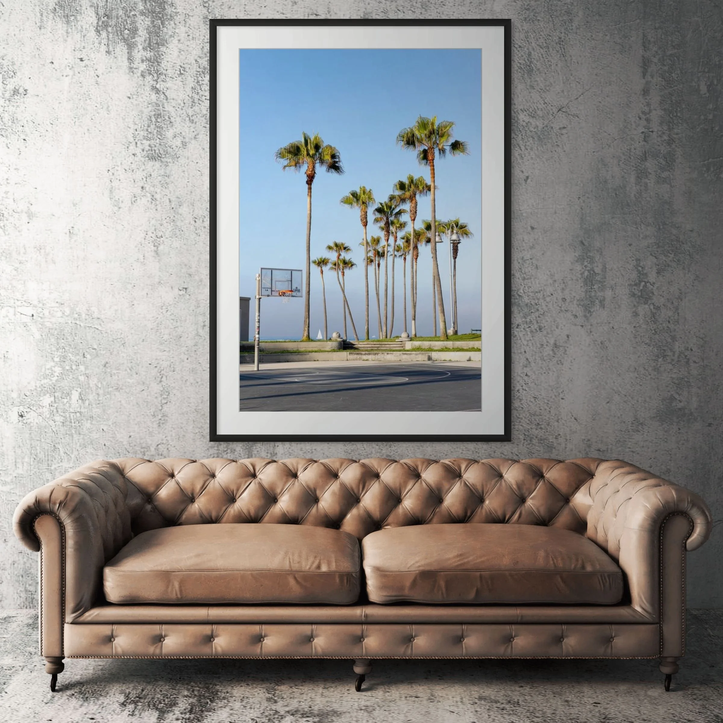 Venice Beach basketball courts framed print displayed above tan leather sofa in living room