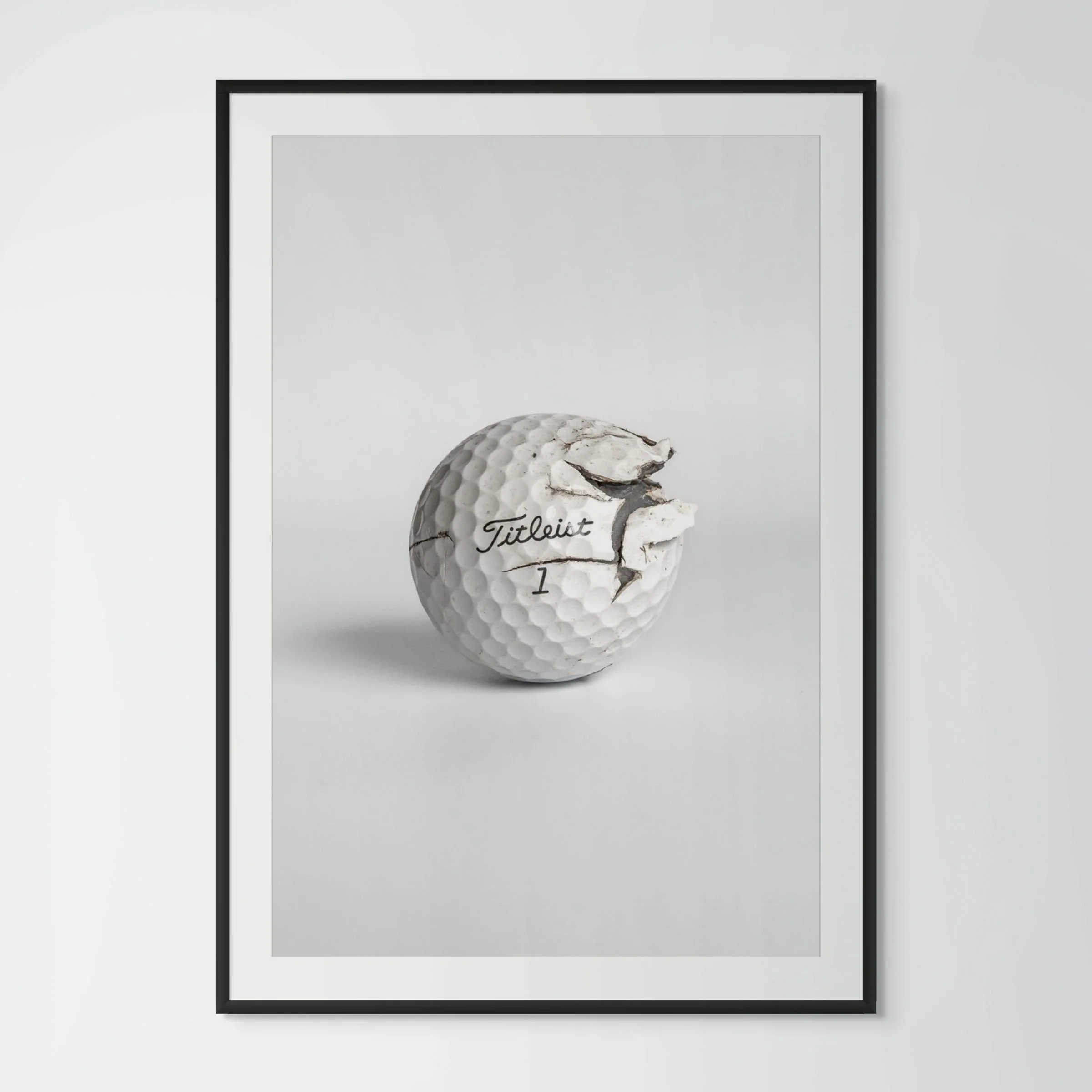 Titleist Pro V1 cracked golf ball framed photography print in black wood frame