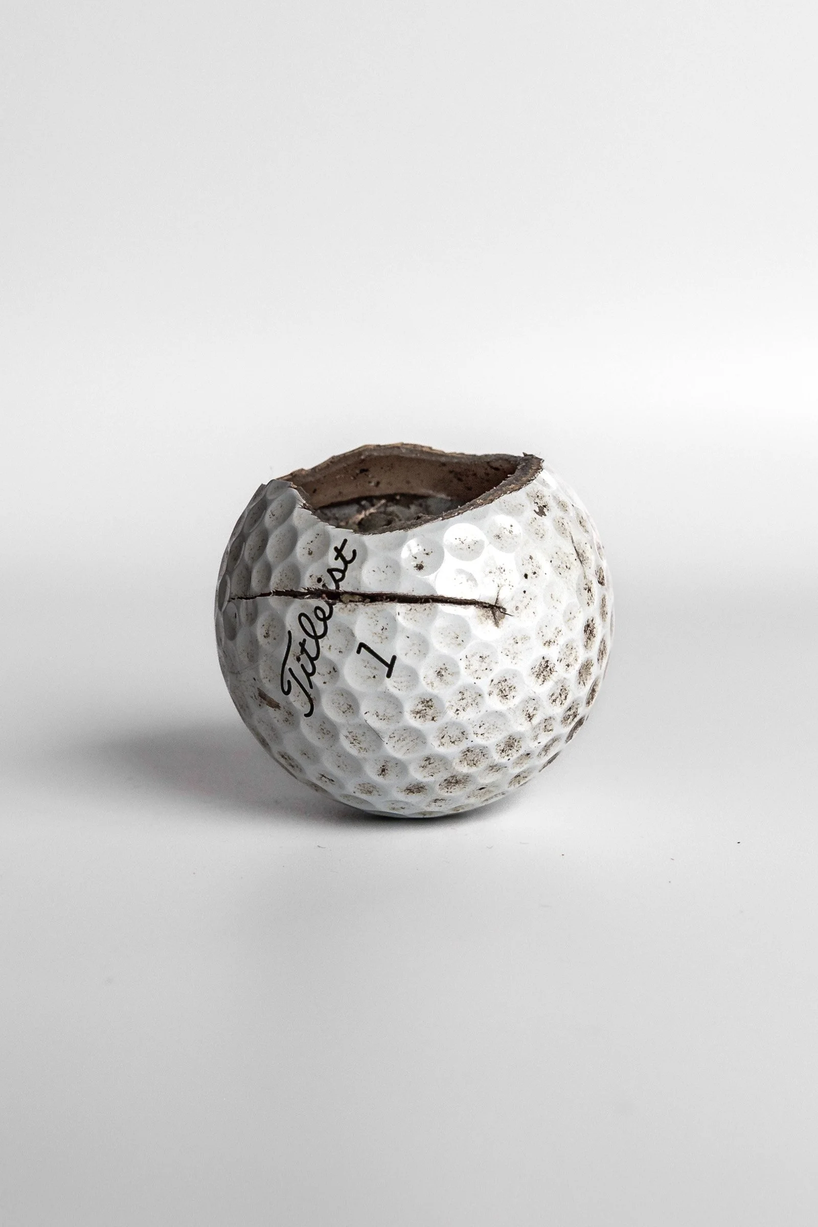 Titleist Pro V1 golf ball split along equator showing interior white background