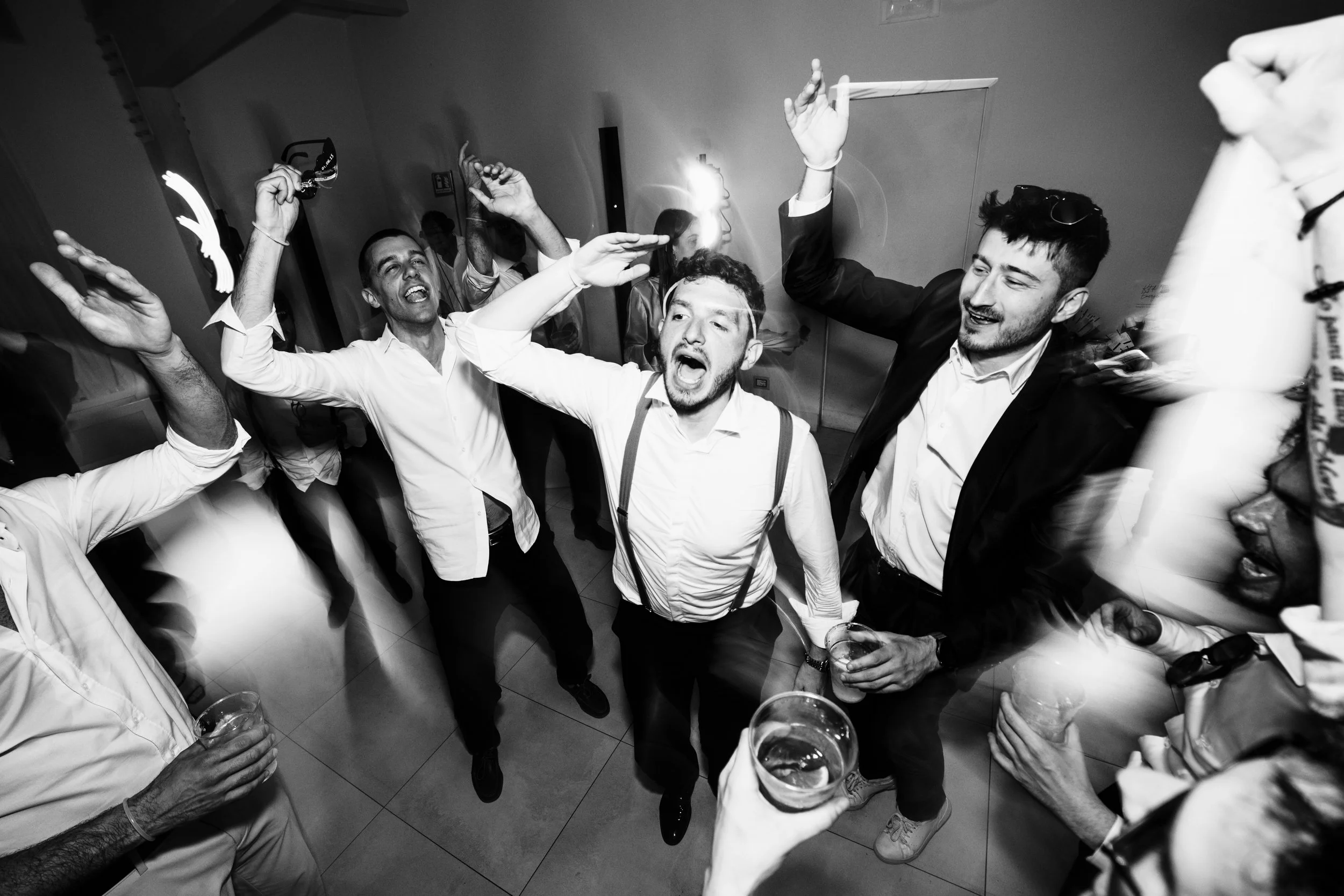 Gruppo di persone che ballano e si divertono in un party, scene vivace in bianco e nero.