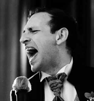 Uomo che canta con energia, vestito in modo formale