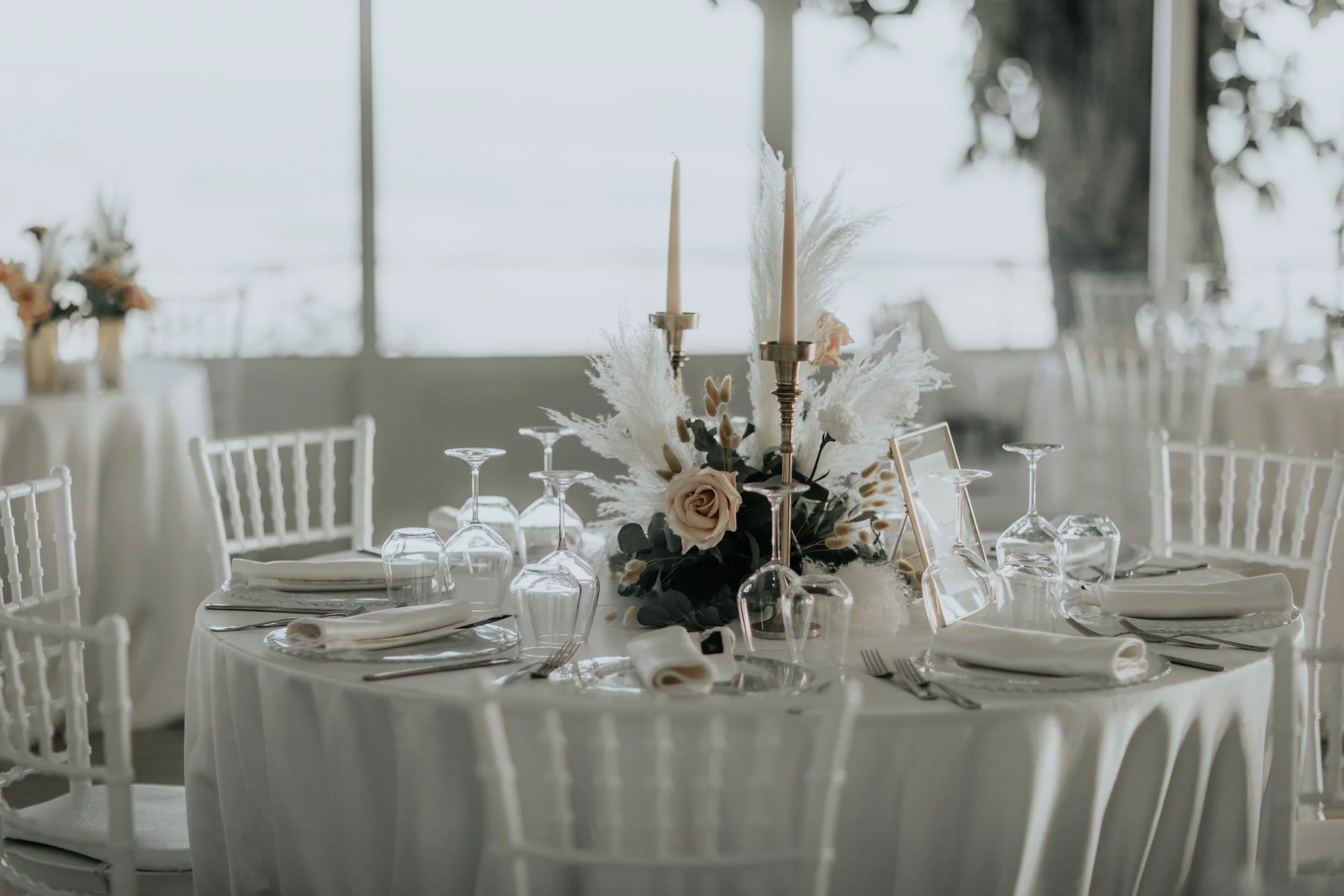 Tavolo da pranzo decorato con fiori e candele in un ambiente luminoso e elegante