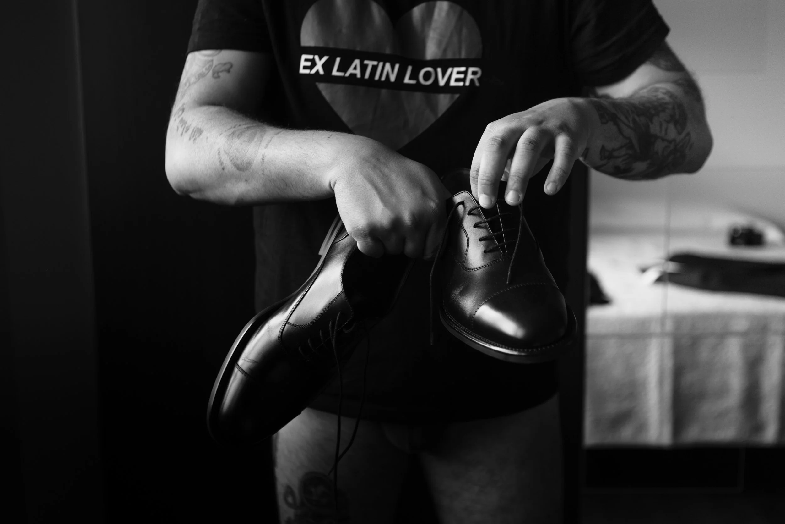 Persona che sta infilando un paio di scarpe eleganti nere in una stanza