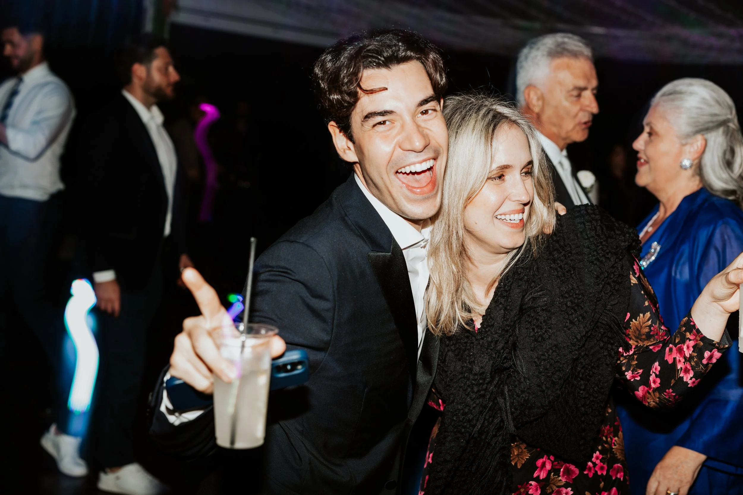 Persone che si divertono a una festa elegante, sorridendo e interagendo in un ambiente vivace.