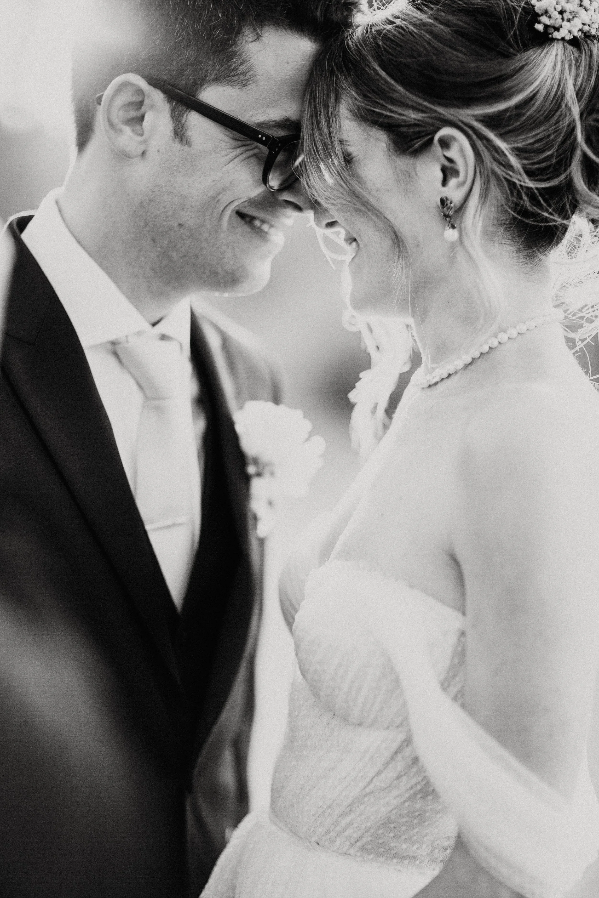 Una coppia di sposi in profilo, sorridenti e molto affiatati, si sta baciando con il naso toccandosi, durante il loro matrimonio. Villa dal Pozzo