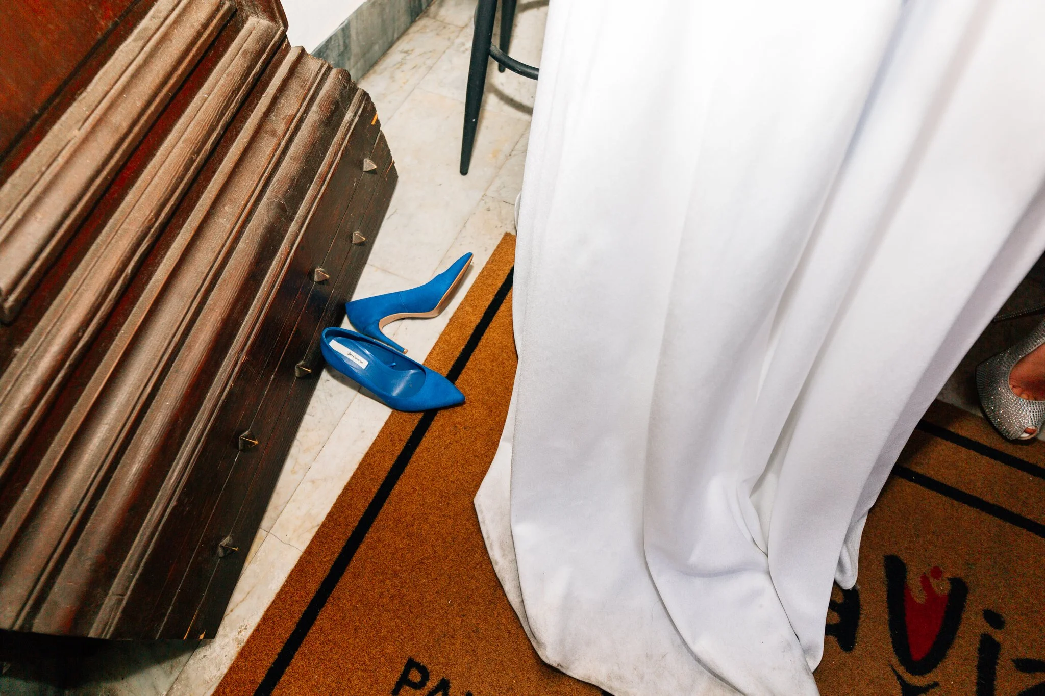Un paio di scarpe blu a punta e tacco alto sopra un tappeto o una porta.
