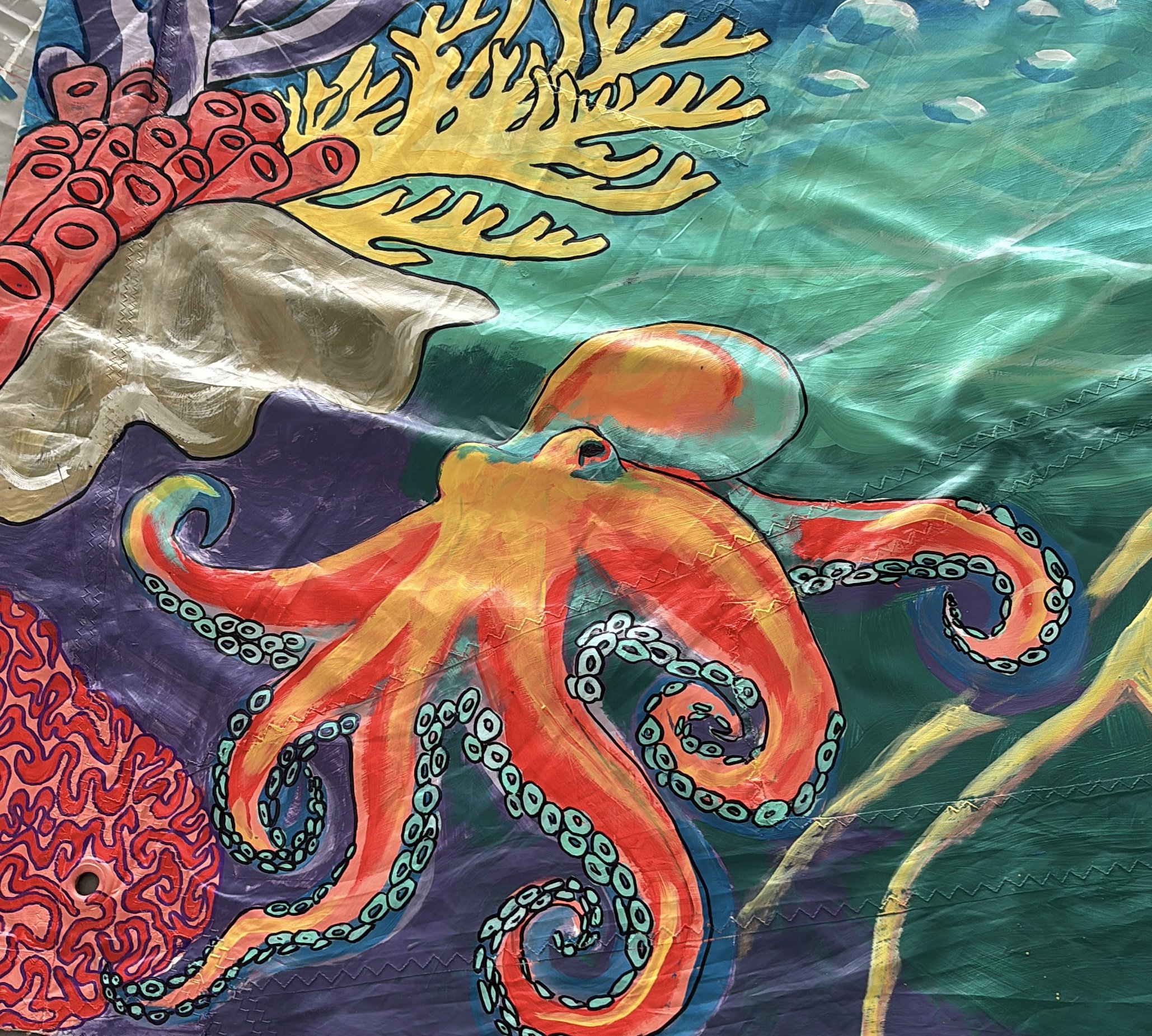 Colorful fish and coral underwater scene with an octopus in orange, red, and yellow hues, surrounded by coral and sea plants.