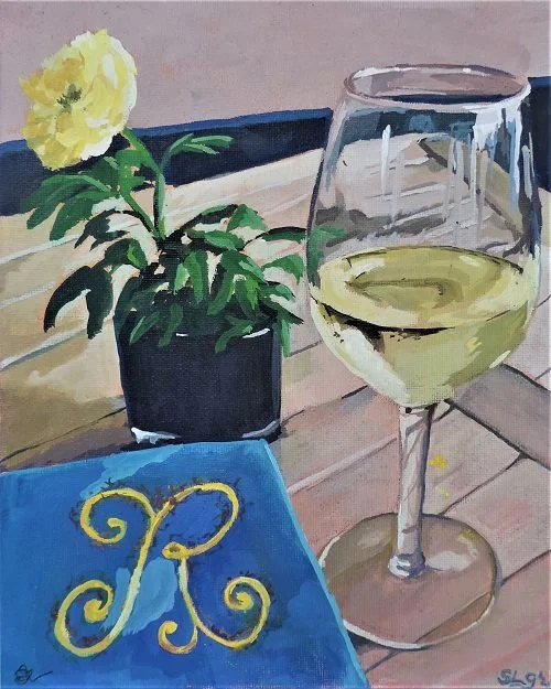 A painting of a glass of white wine, a potted yellow flower, and a blue cloth with a decorative yellow letter 'R' on a wooden table.