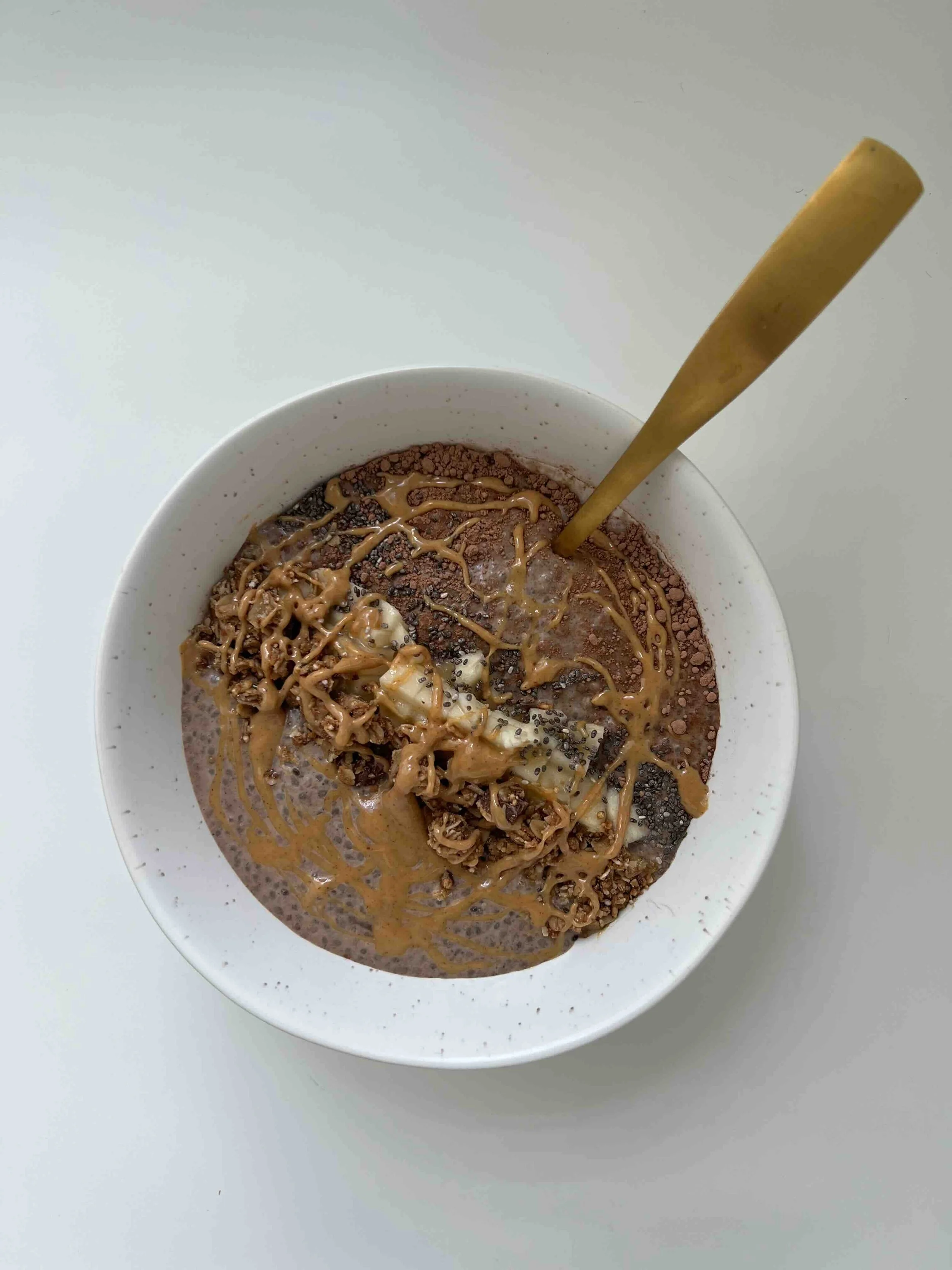 A bowl of healthy chia pudding with granola, banana, and peanut butter to support a balanced diet.
