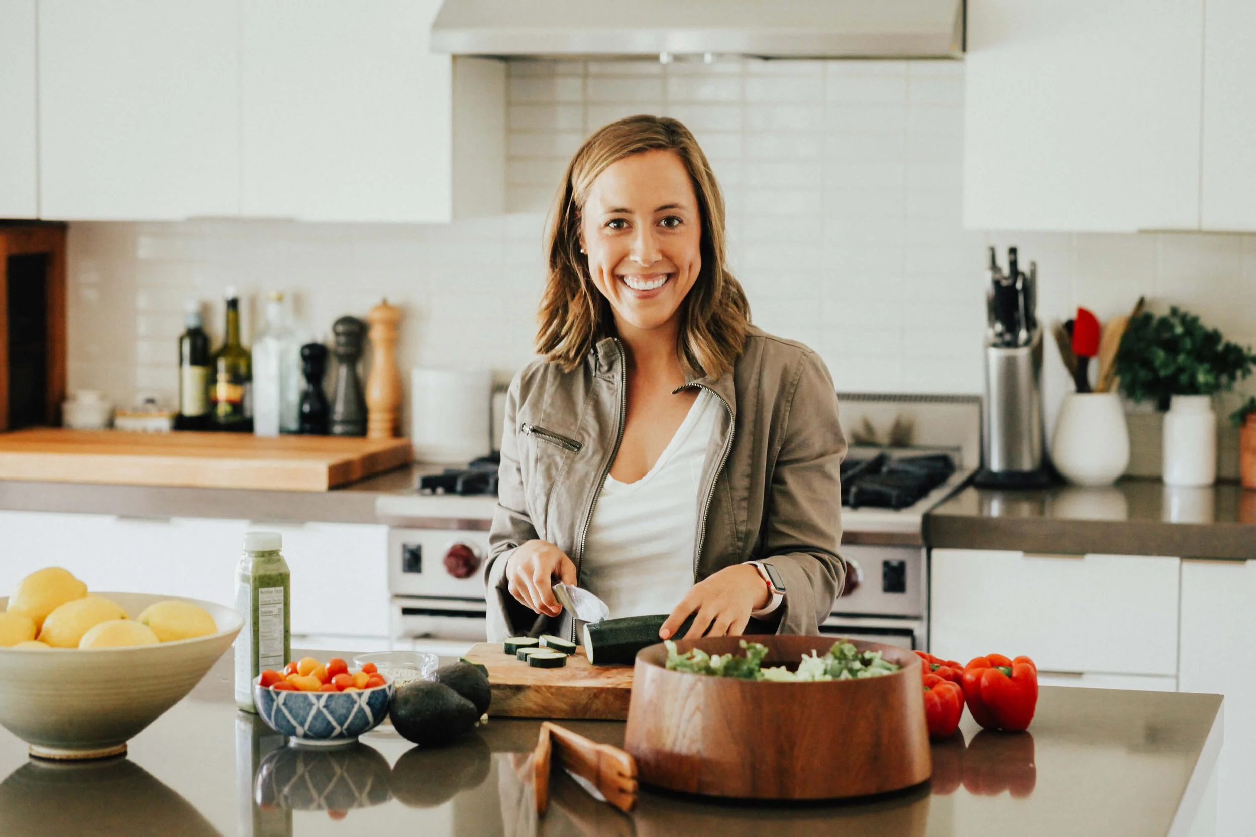 Lia in the kitchen chopping vegetables for a salad, representing a healthy, sustainable lifestyle.