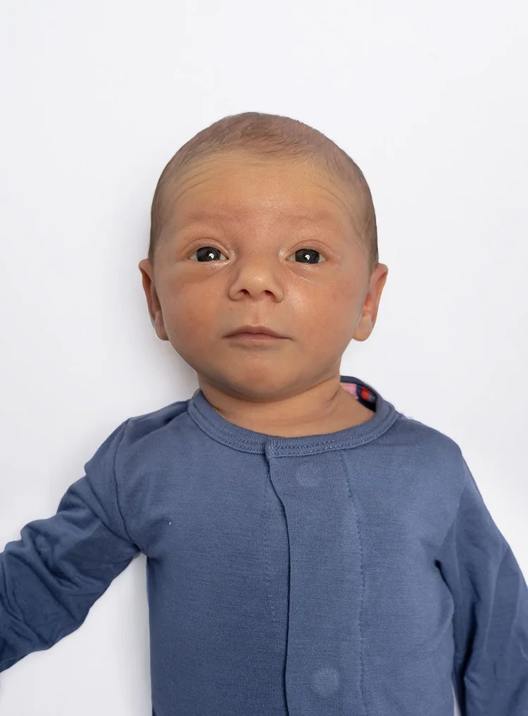 Newborn baby passport photo Los Angeles — four-week-old lying flat on white, eyes open, no shadows, Karen Vaisman Photography