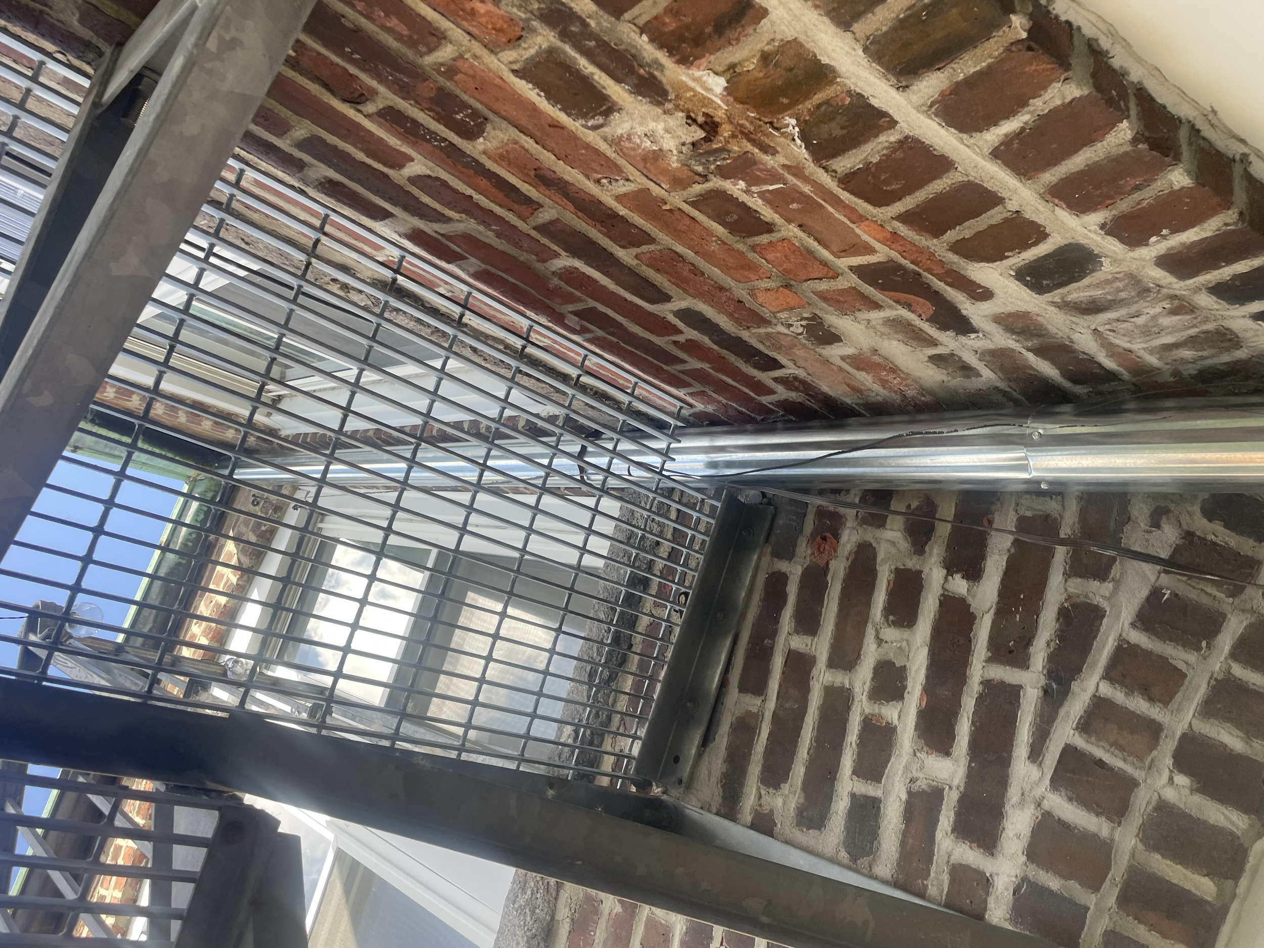 View of a metal grate and brick wall